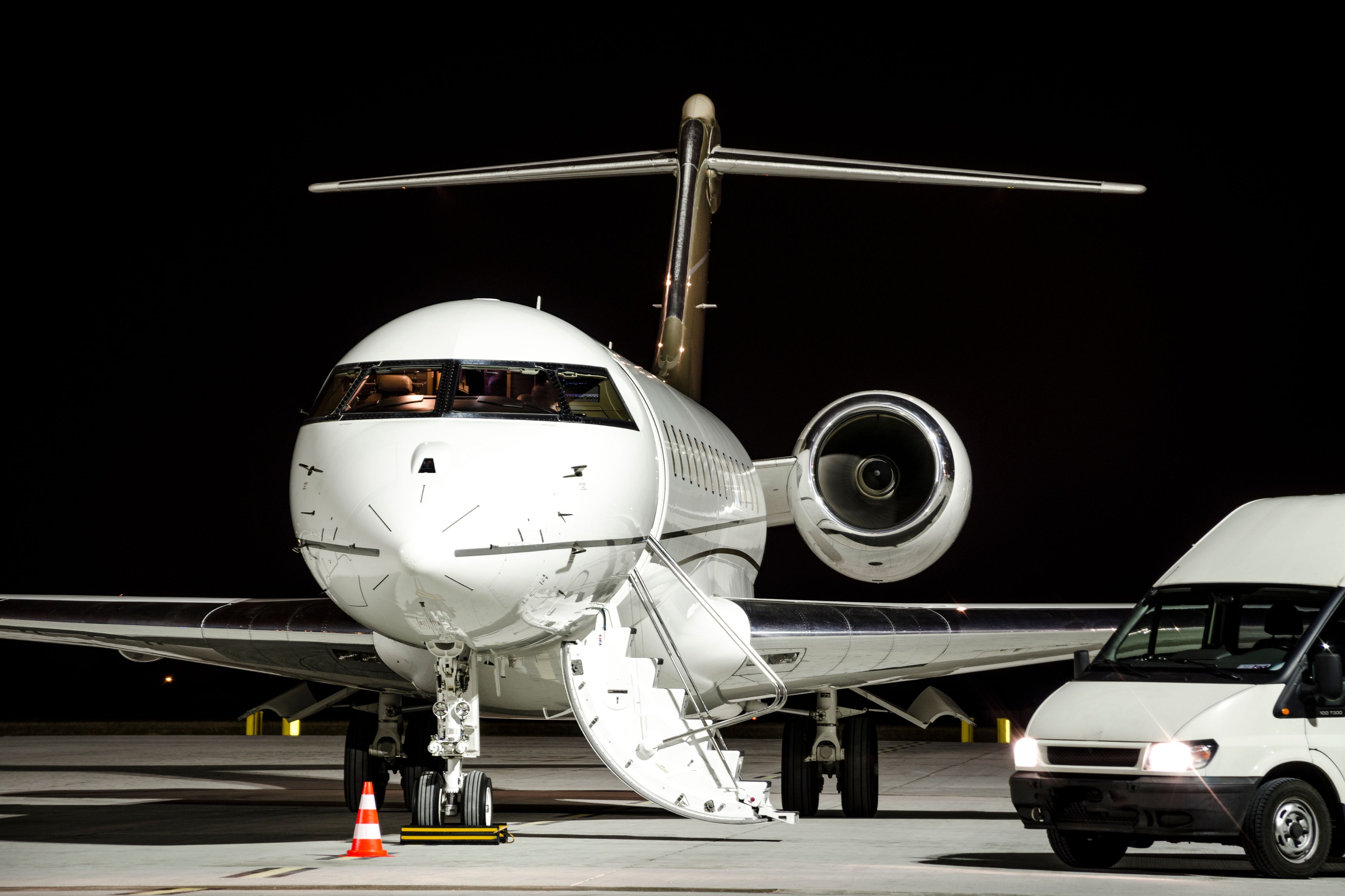 A van parked next to a private jet.