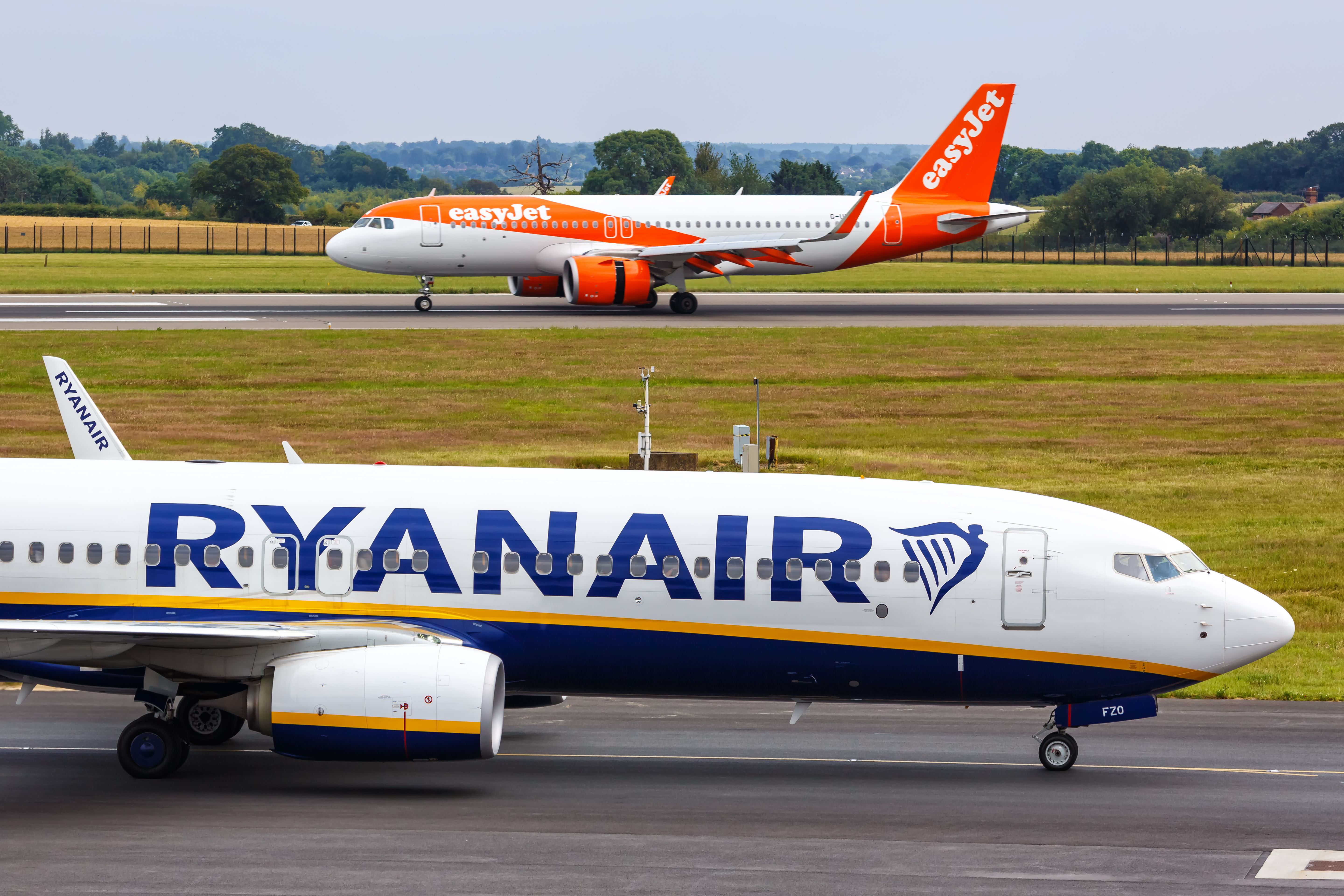 Ryanair and easyJet aircraft taxiing at London Luton Airport.