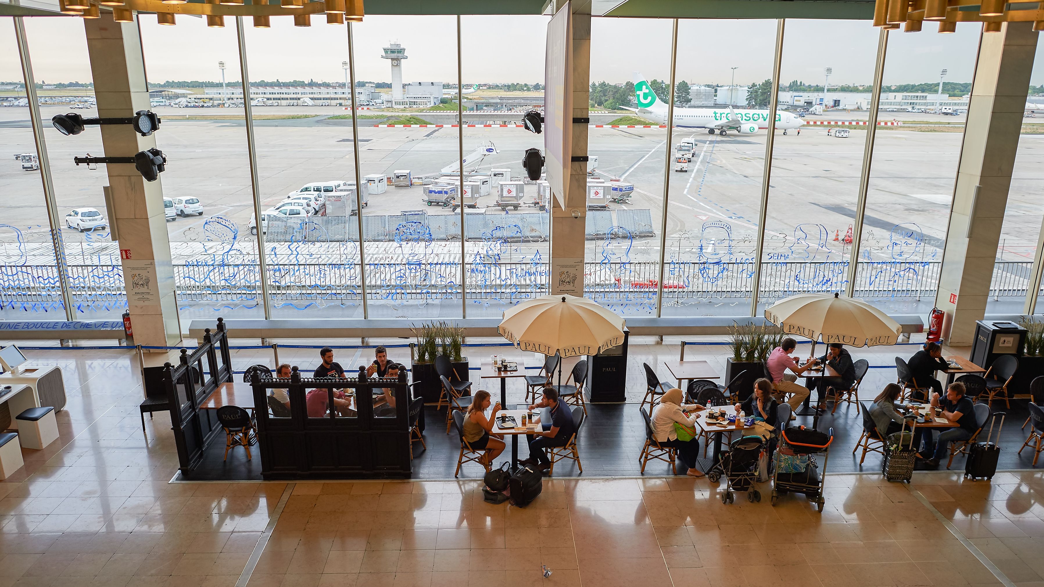 Passengers eating at a restaurant inside Paris Orly Airport.