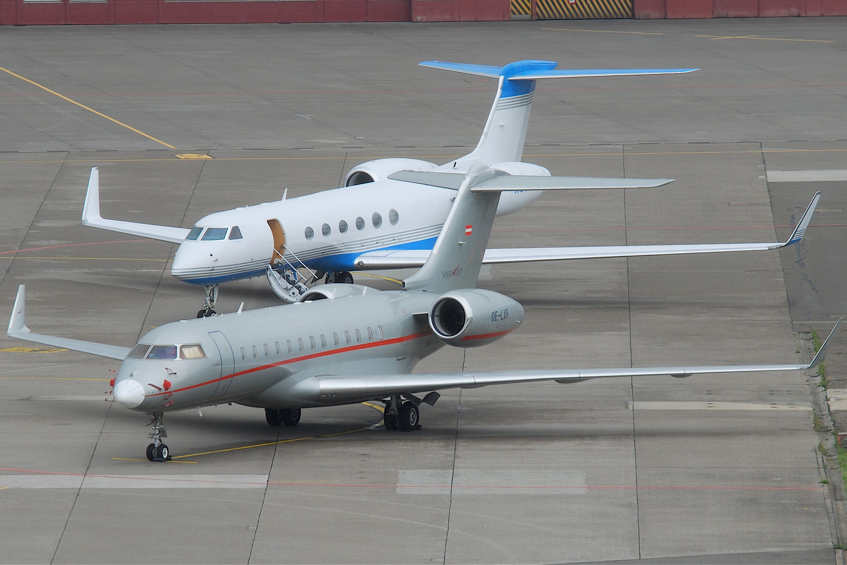 Two private jets on the ground at an unidentified airport.