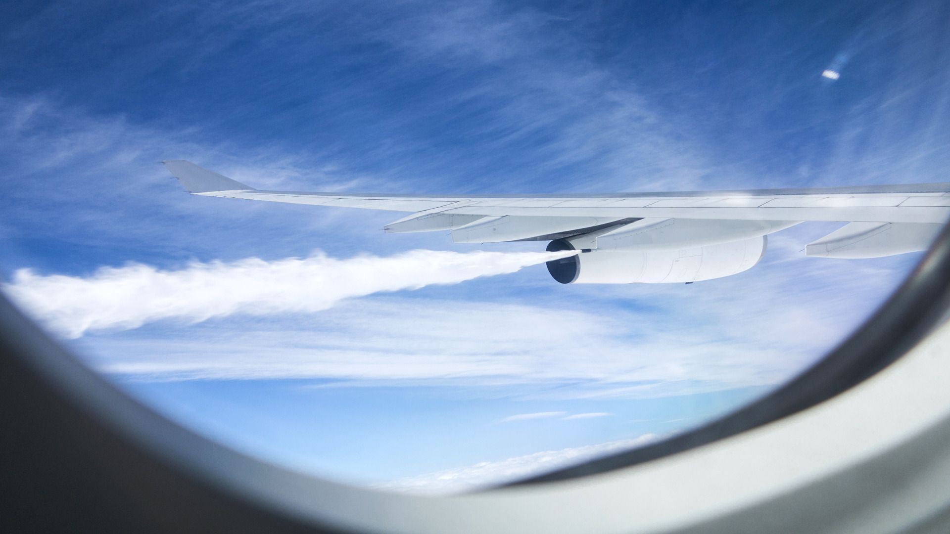 Looking through an aircraft window as the plane dumps fuel 