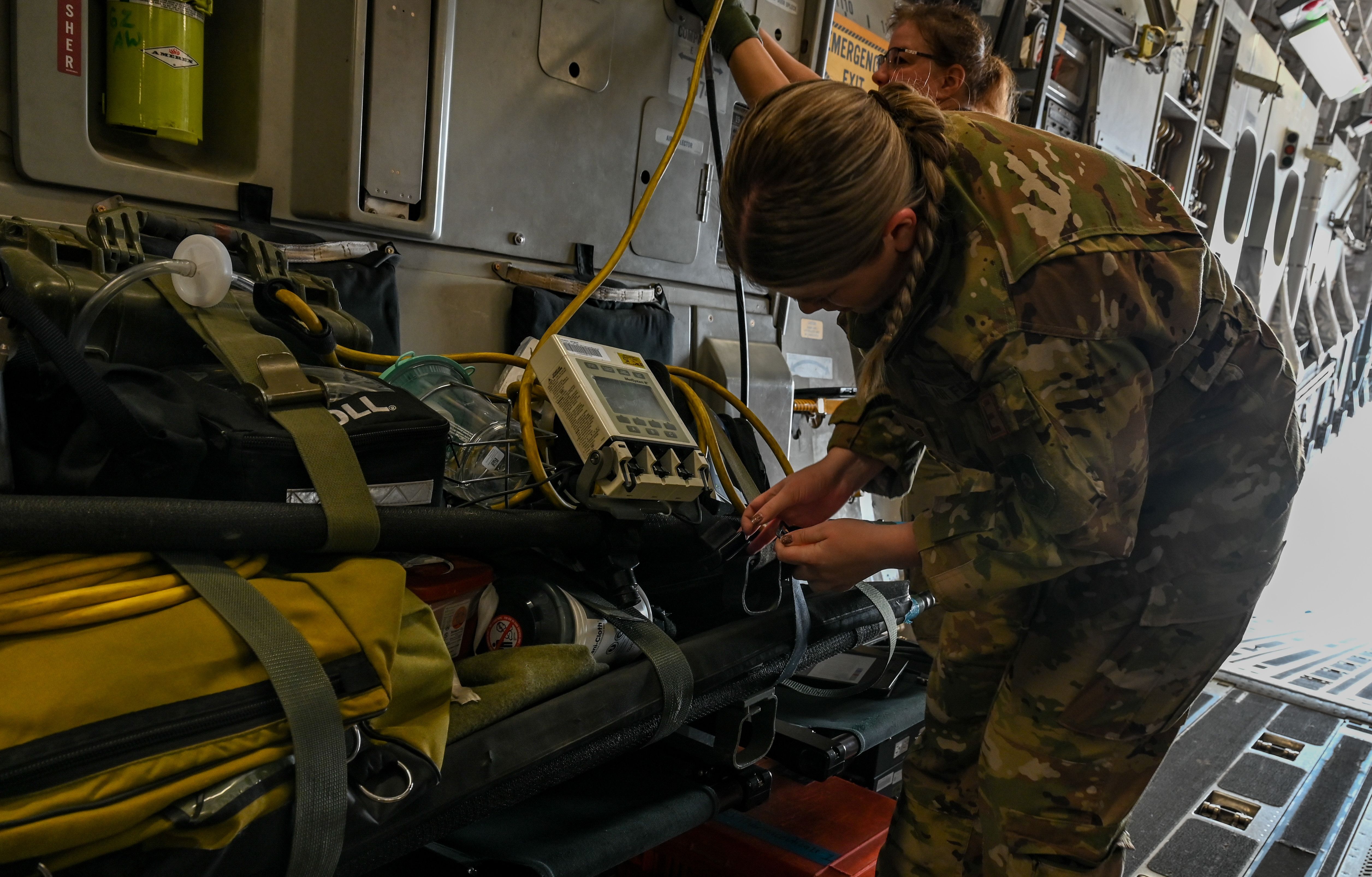 A U.S. Airman assigned to the 379th Expeditionary Aeromedical Evacuation Squadron, secure a litter containing medical equipment on a C-17 Globemaster III assigned to the 8th Expeditionary Airlift Squadron at Al Udeid Air Base, Qatar, Dec. 20, 2022. 