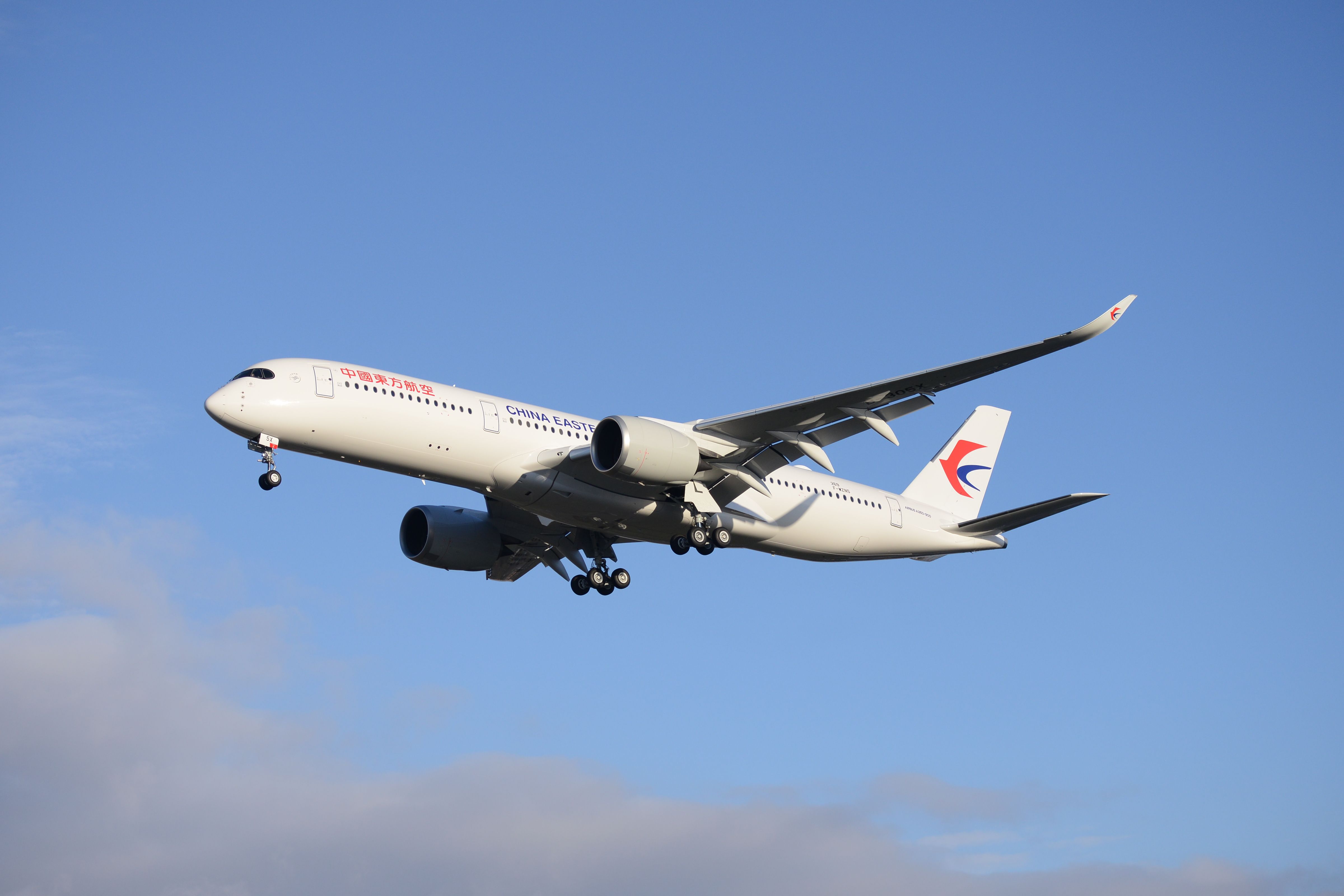 A China Eastern Airlines Airbus A350-900 flying in the⁢ sky.