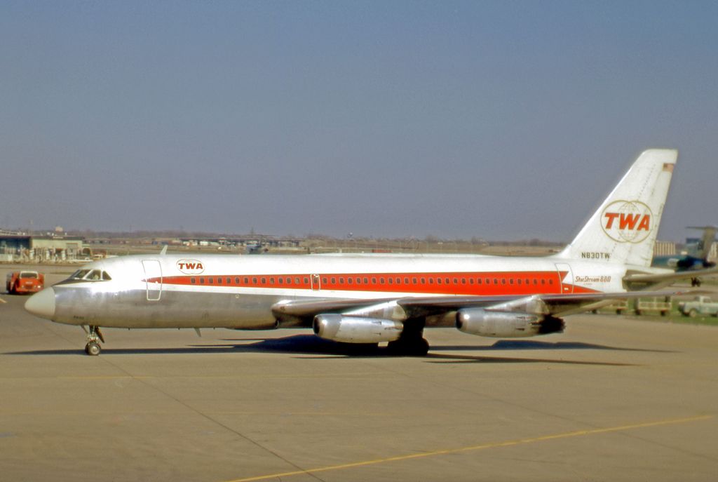 A TWA Convair 880 taxiing at an airport.
