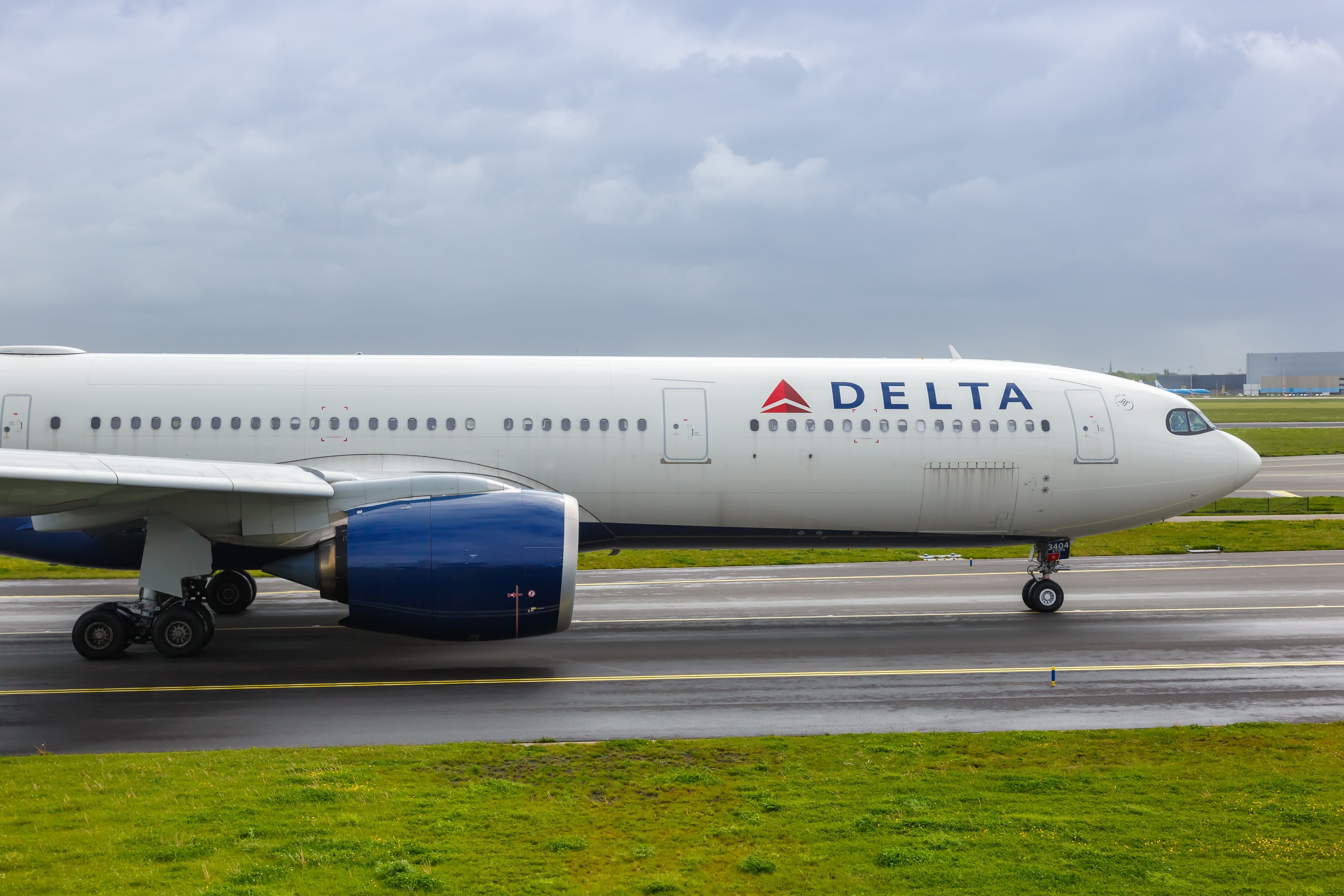 A Delta Air Lines Airbus A330neo on a wet taxiway.