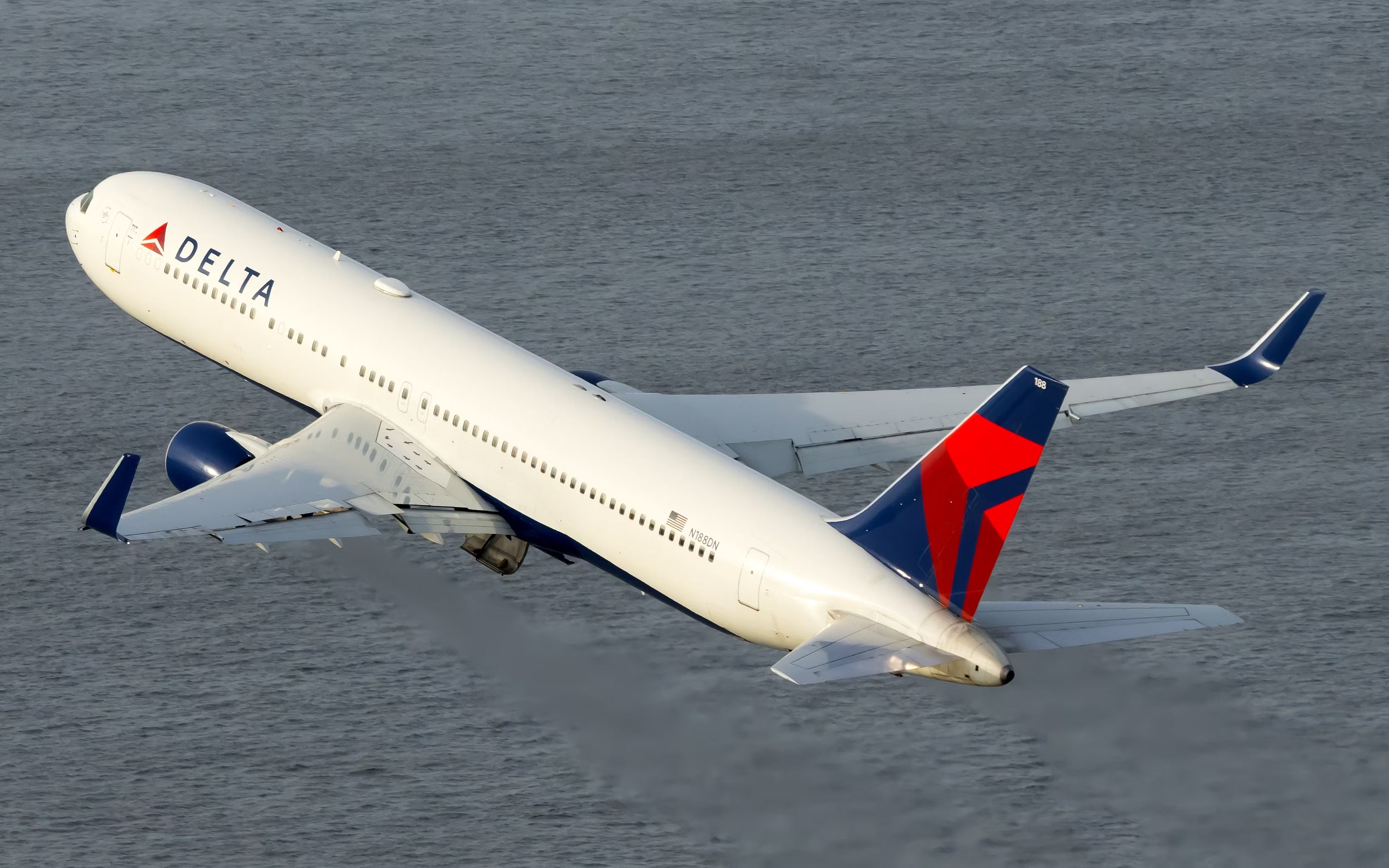 A Delta Air Lines Boeing 767-300(ER) flying over water.