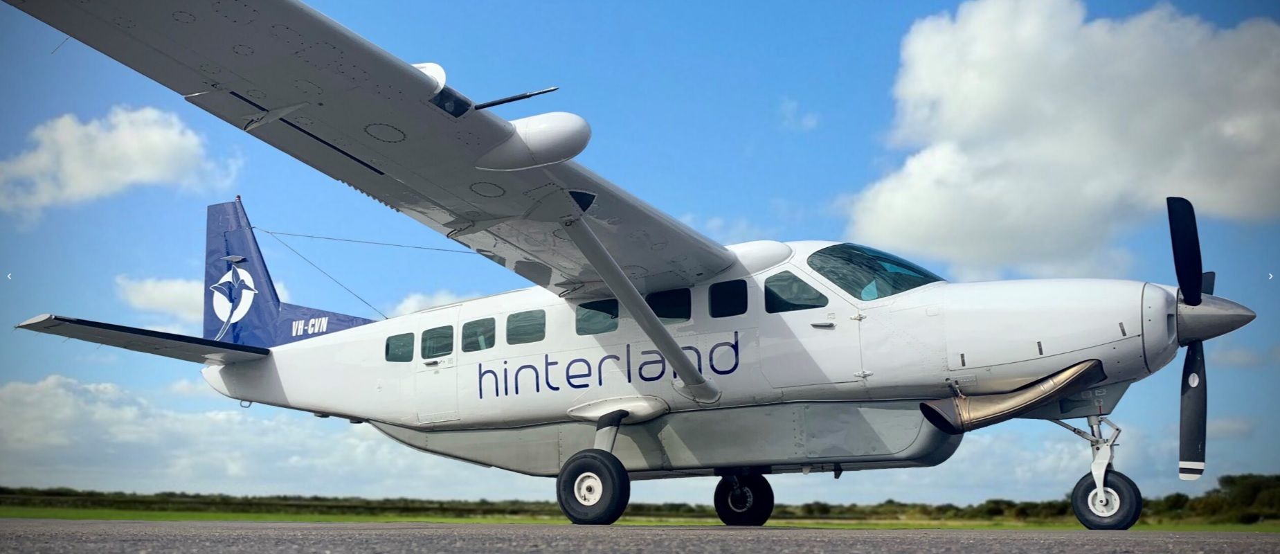 A Hinterland Cessna 208 parked at an airport.