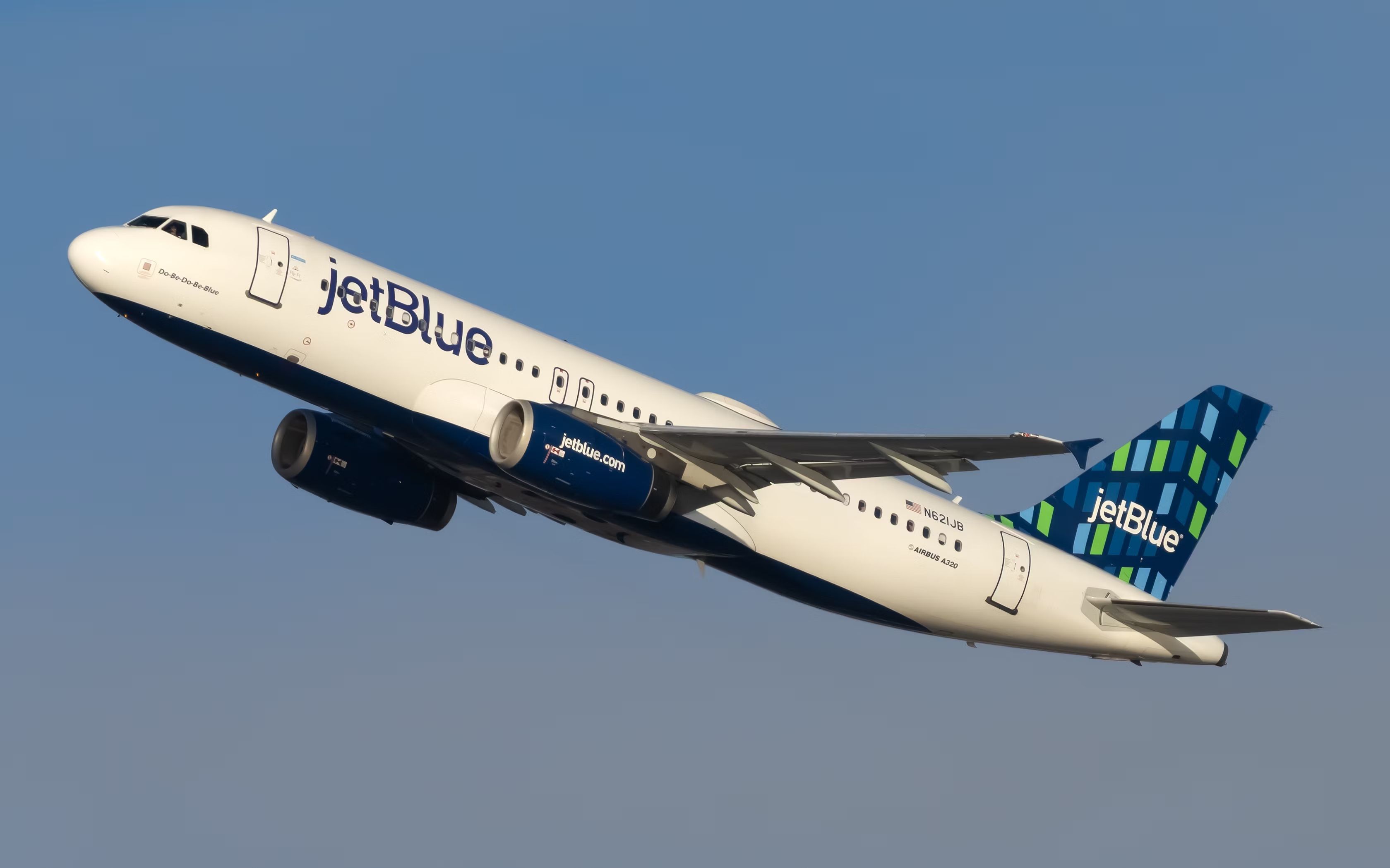 A Jetblue A320-200 flying in the sky.