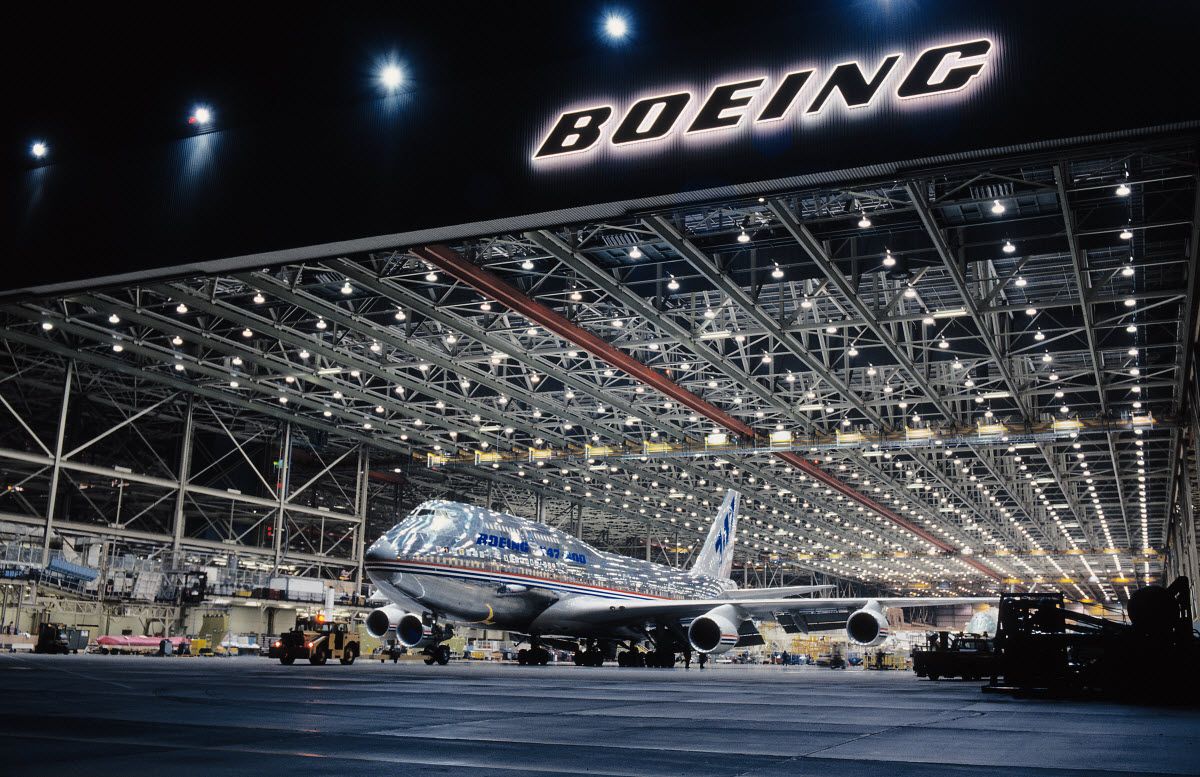 A silver Boeing 747 inside of a Boeing manufacturing facility.