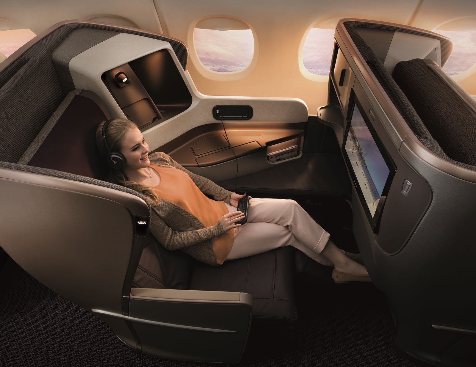 A passenger enjoying inflight entertainment sitting in Singapore Airlines business class.