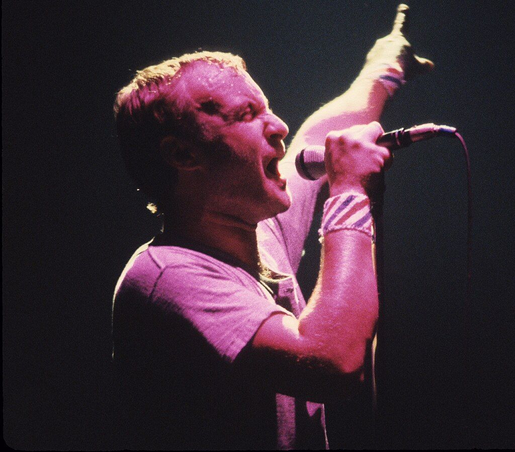 A Photo of Phil Collins singing.