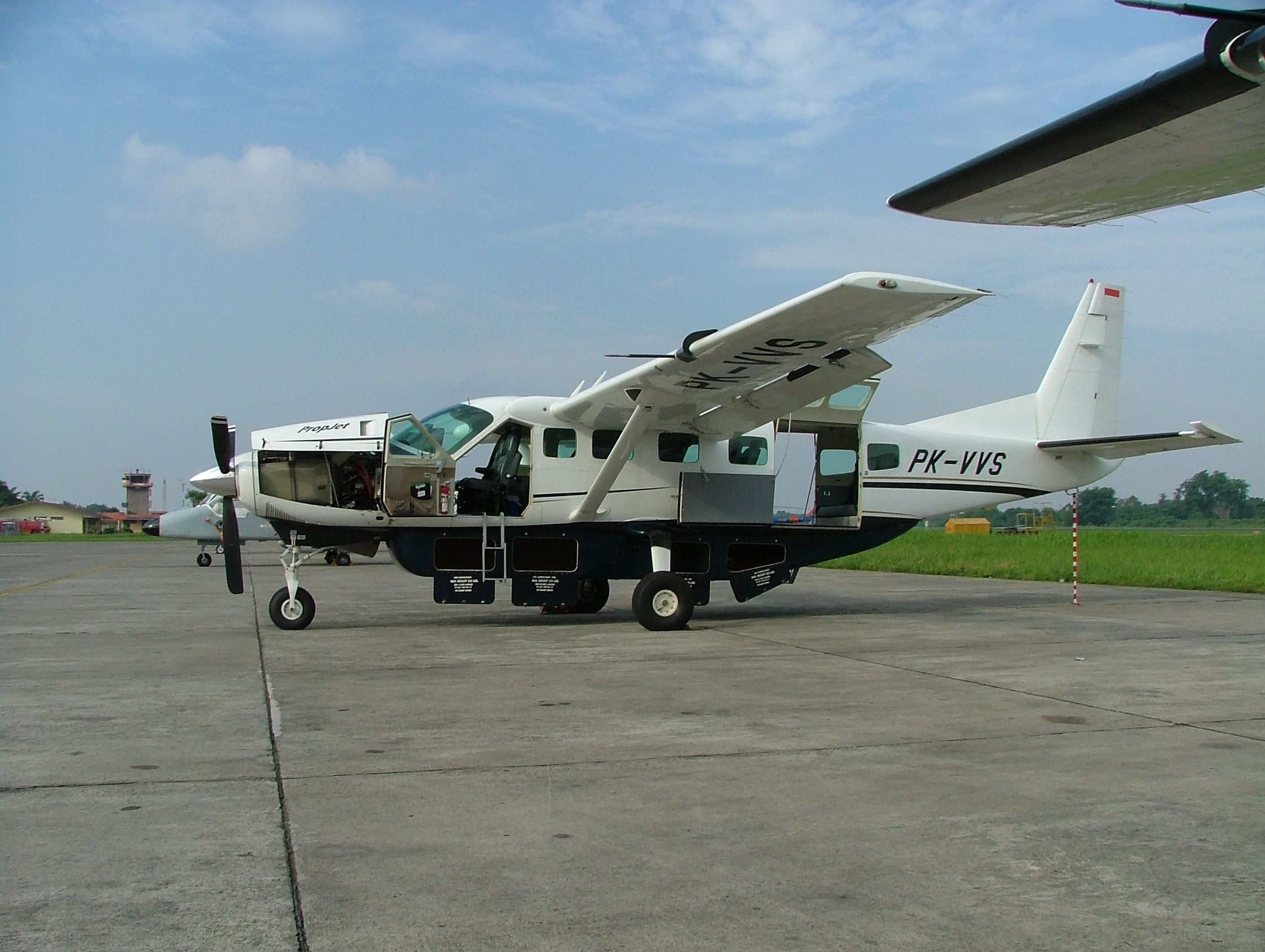 A Susi Air Cessna 208 parked at an airport.