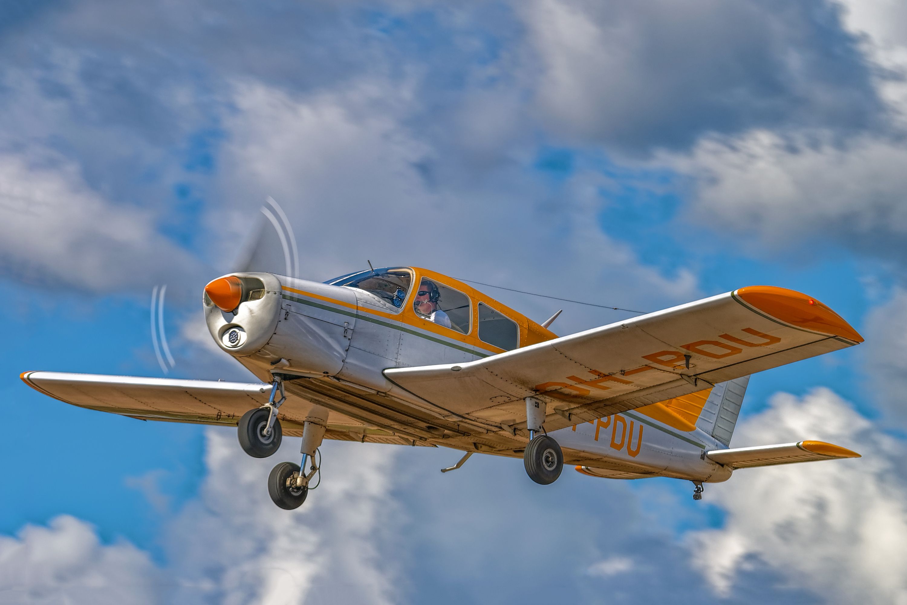 A Piper PA-28 Cherokee flying in the sky.