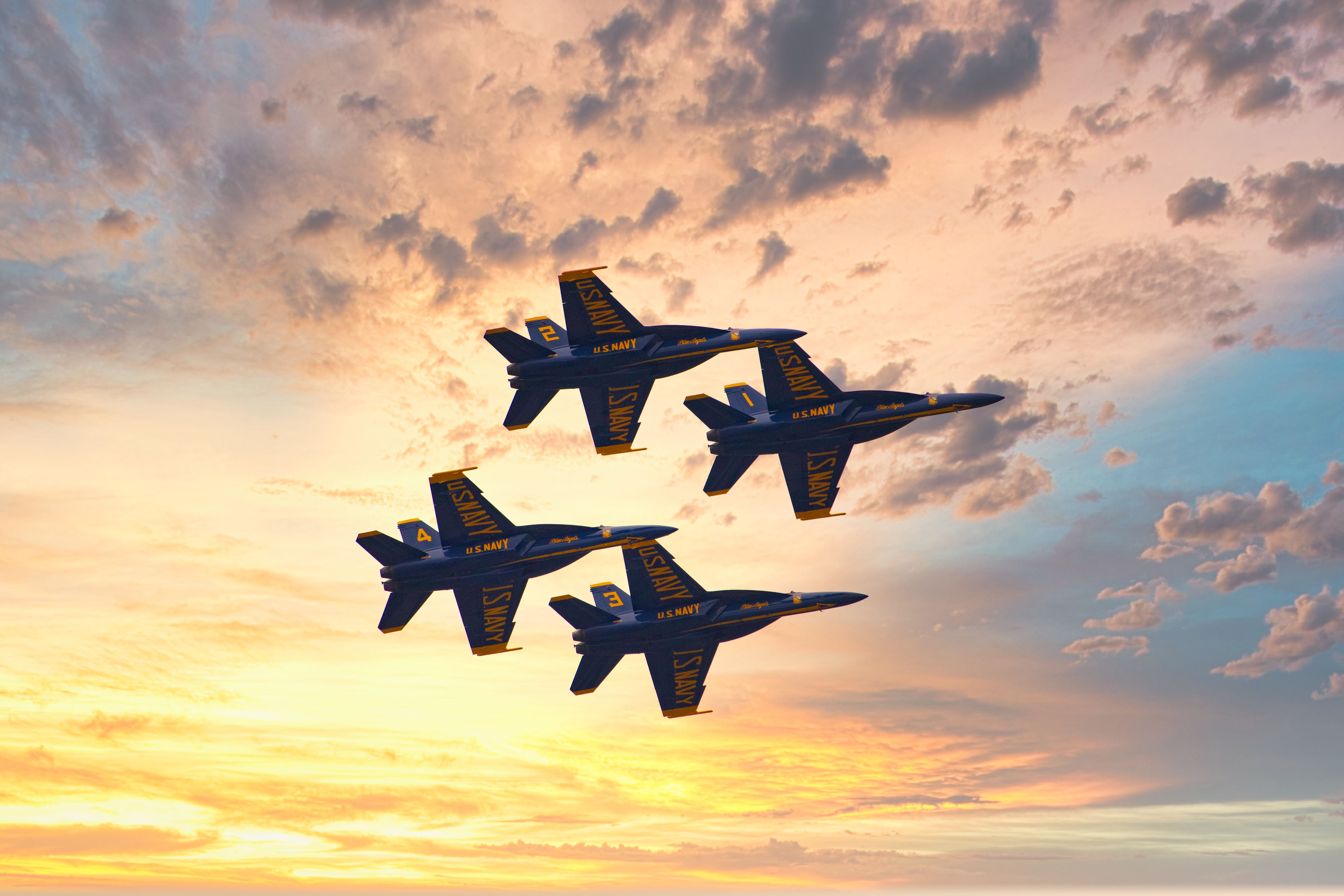 Four Blue Angels aircraft flying in formation.
