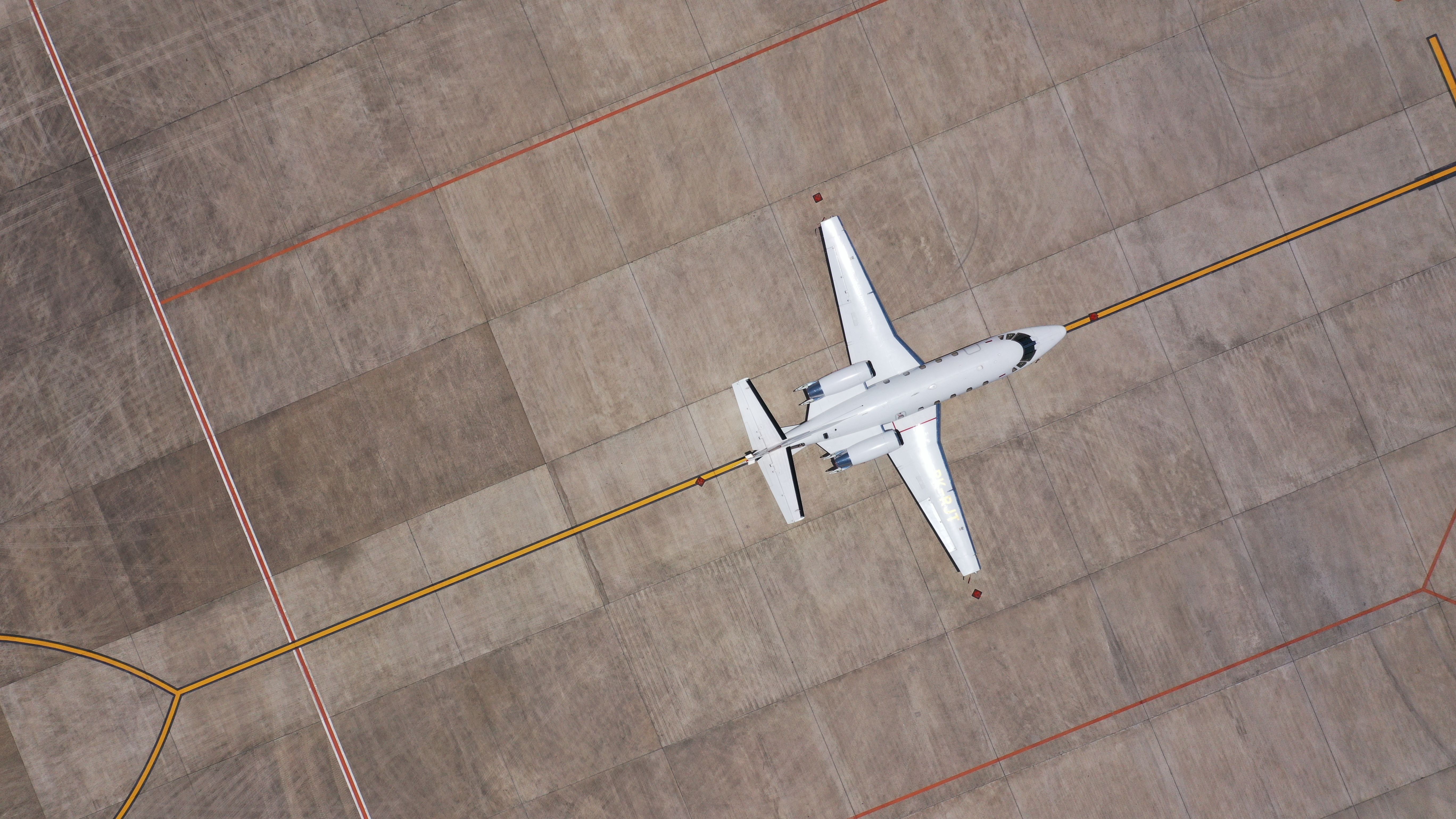 An overhead view of a private jet parked at an airport.