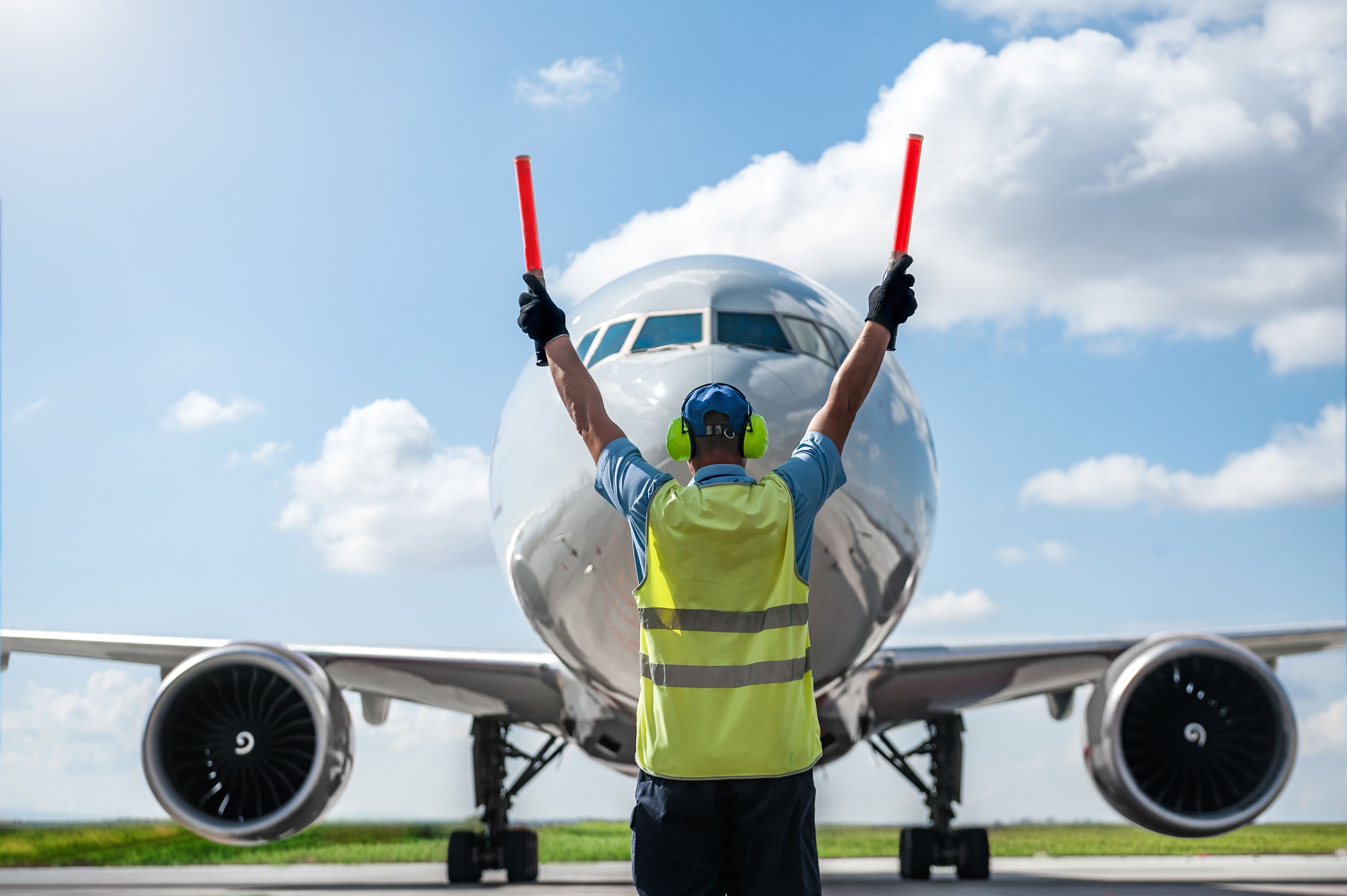 A ground staff member marshaling a Boeing 777. 