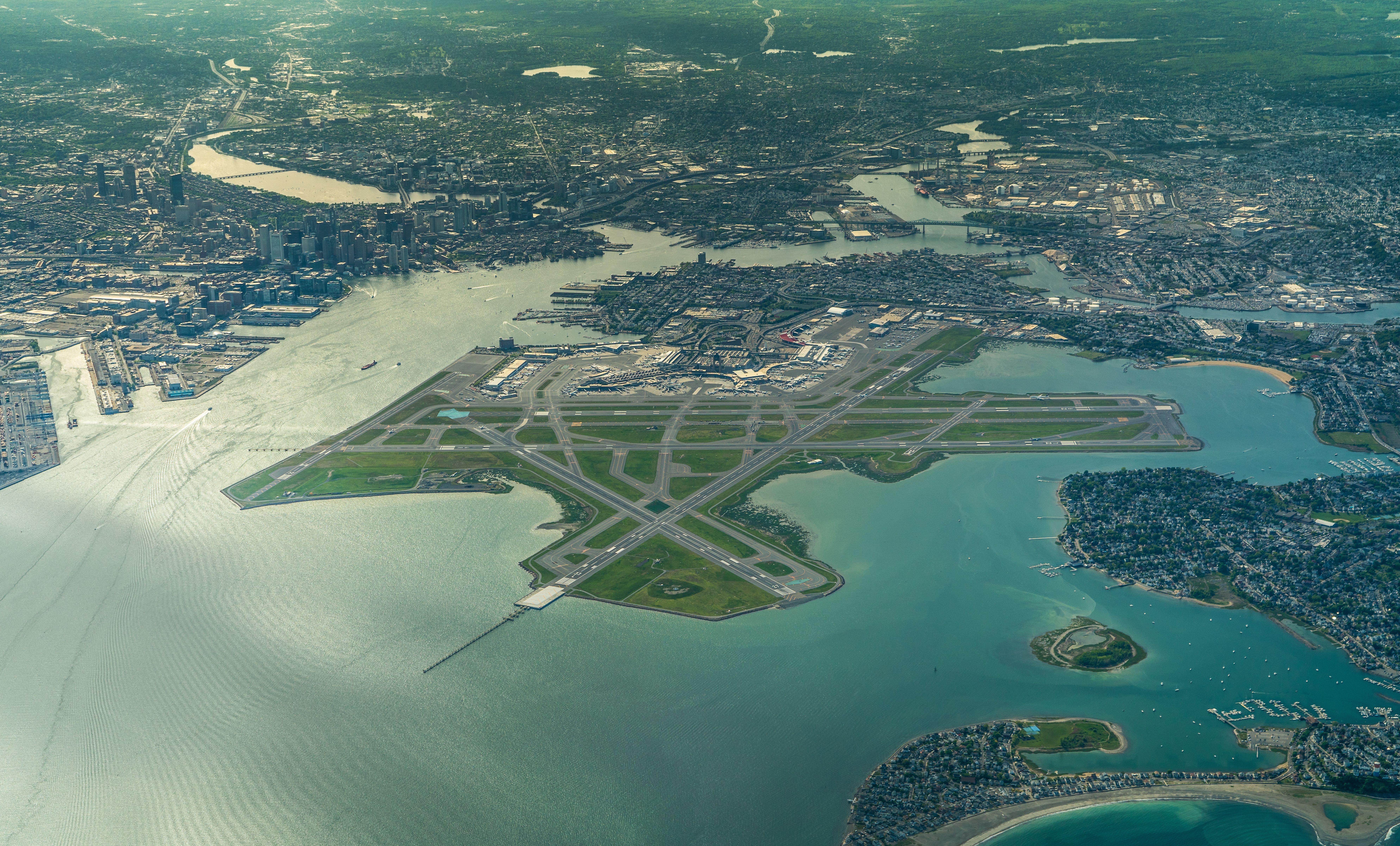 aerial landscape view of "Edward Lawrence Logan International Airport" with runway environment and the City of Boston MA in the background