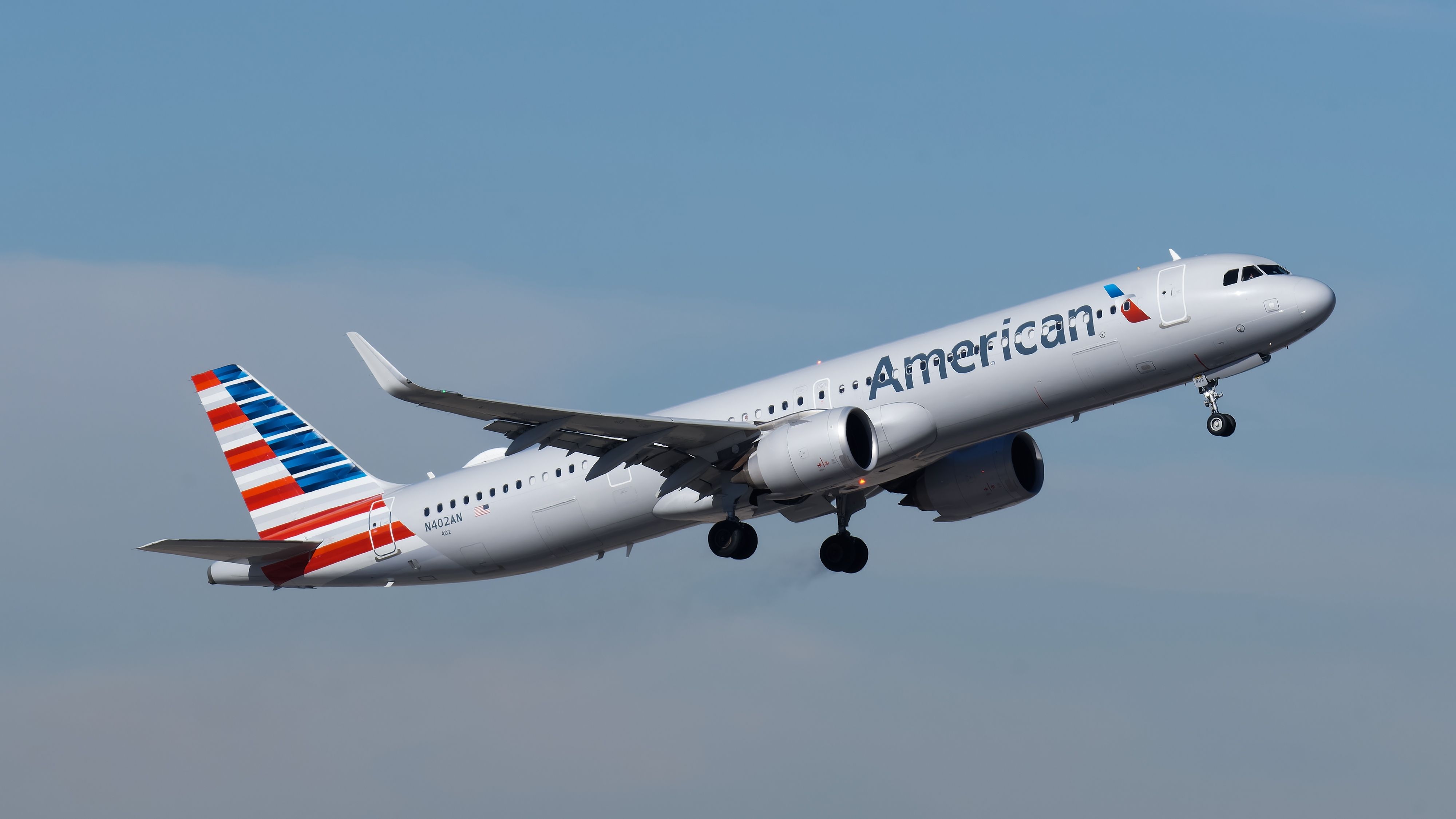 An American Airlines Airbus A321neo flying in the sky.