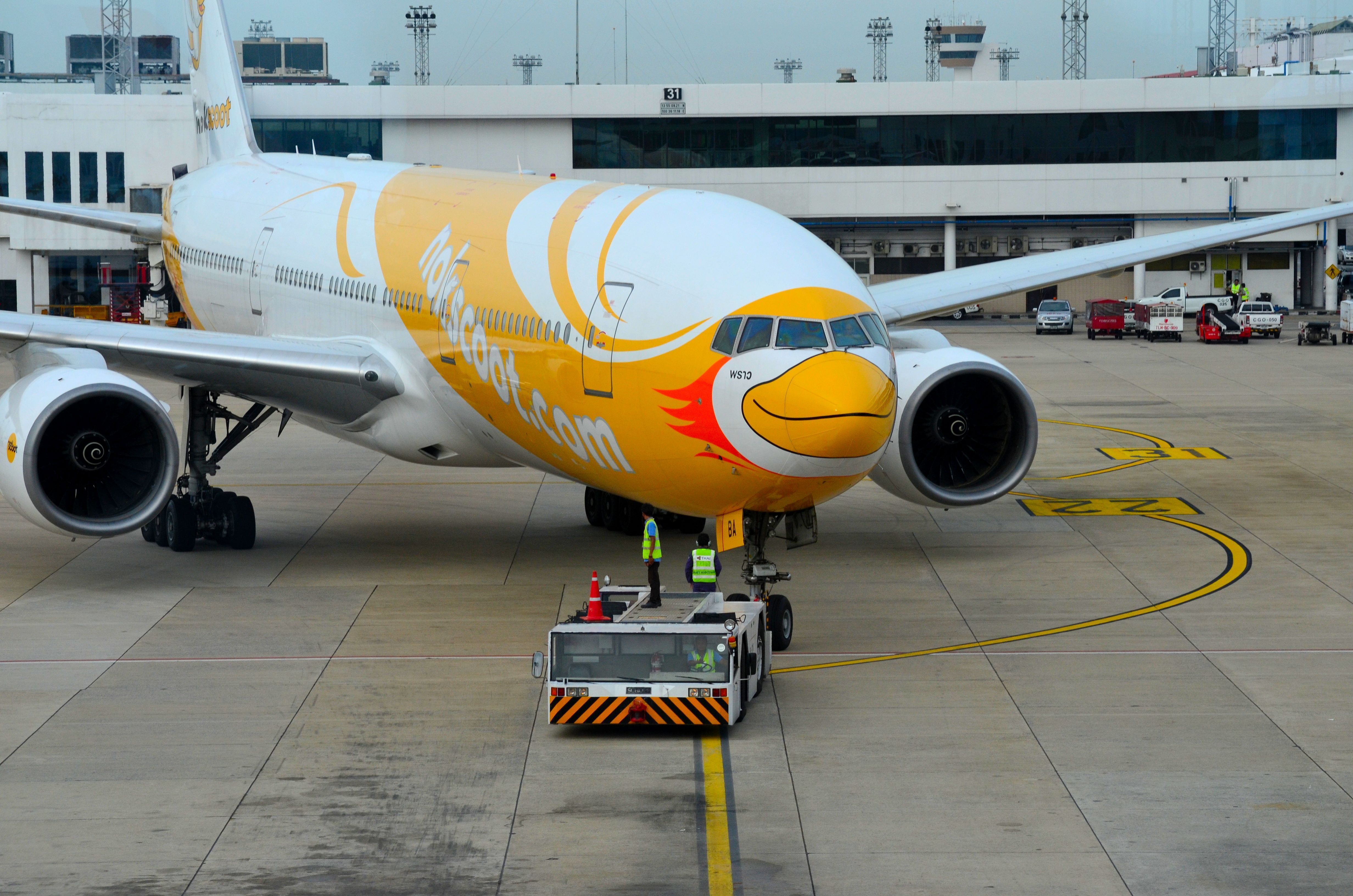 A NokScoot Boeing 777-200 being pushed back.