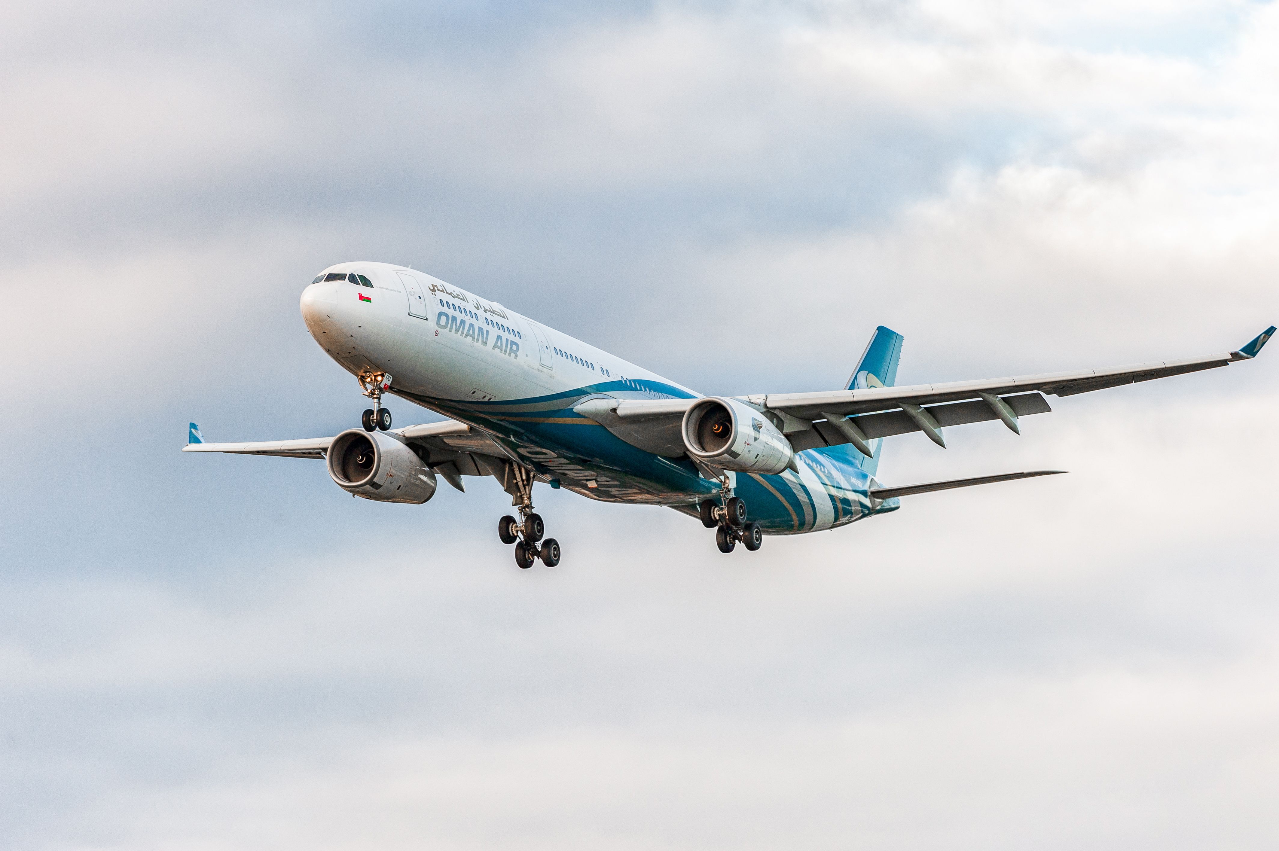 An Oman Air Airbus A330 flying in the sky.