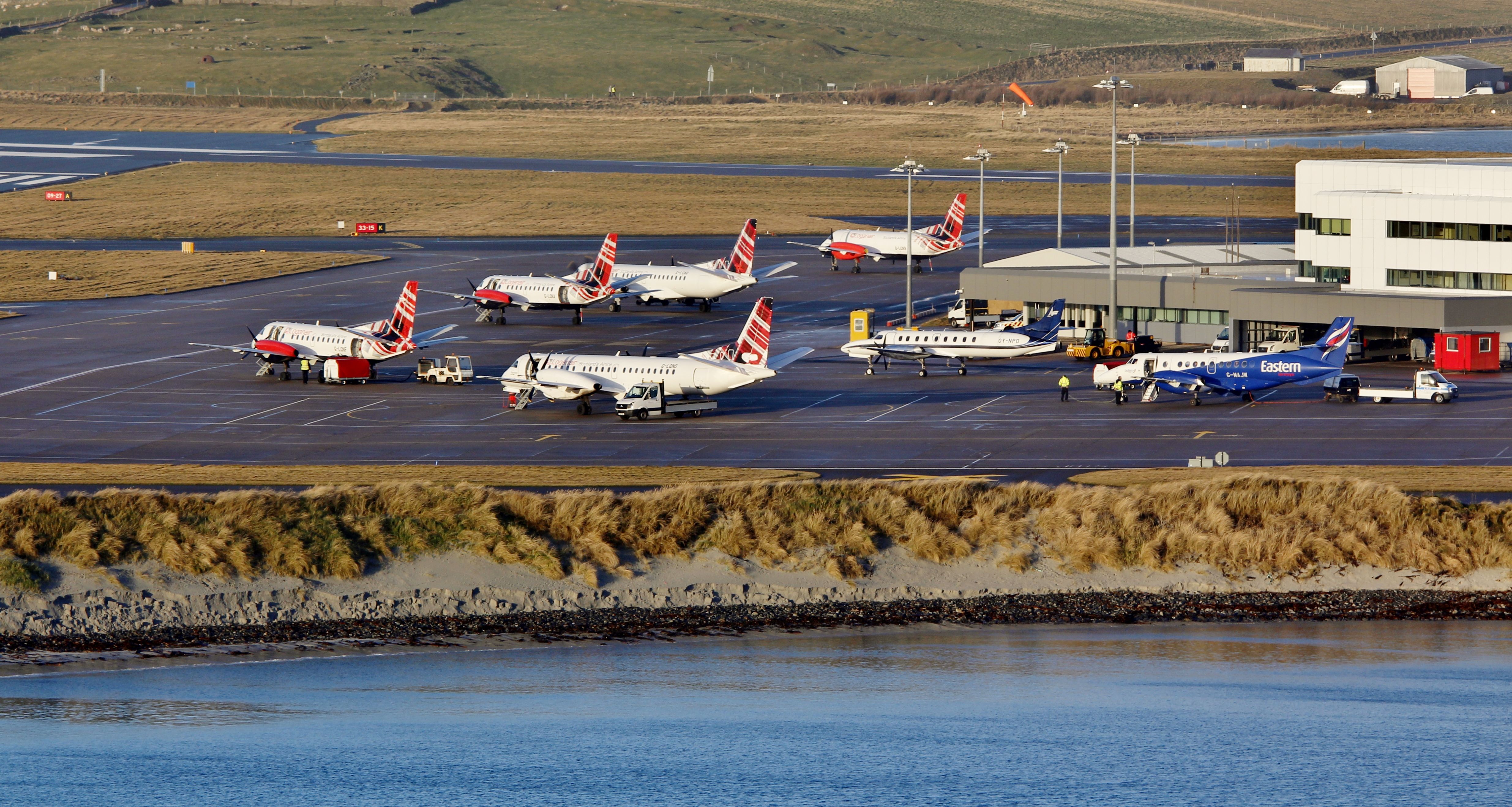 A few Loganair aircraft parked at an airport in Scotland.