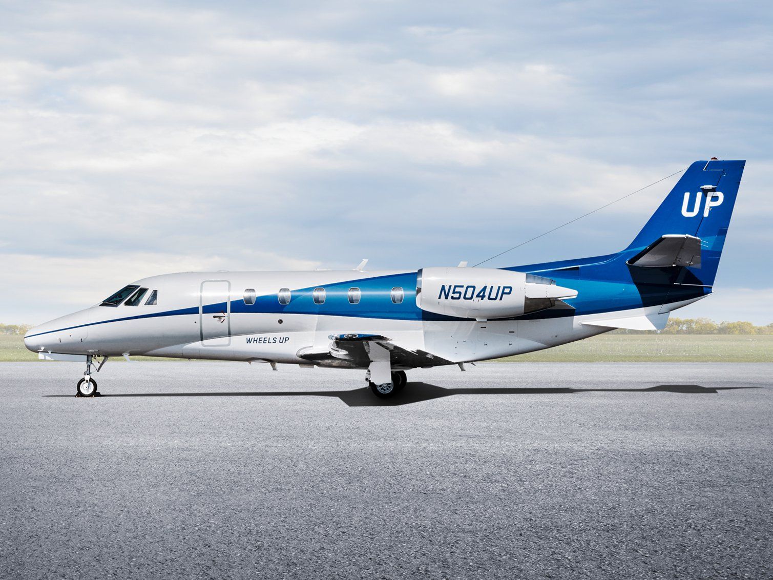 A Wheels Up Cessna Citation Excel on an airport apron.
