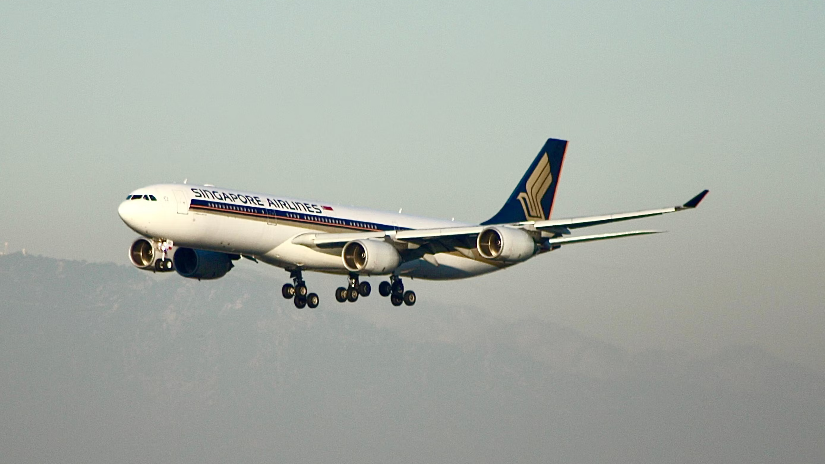 A Singapore Airlines A340-300 flying in the sky.