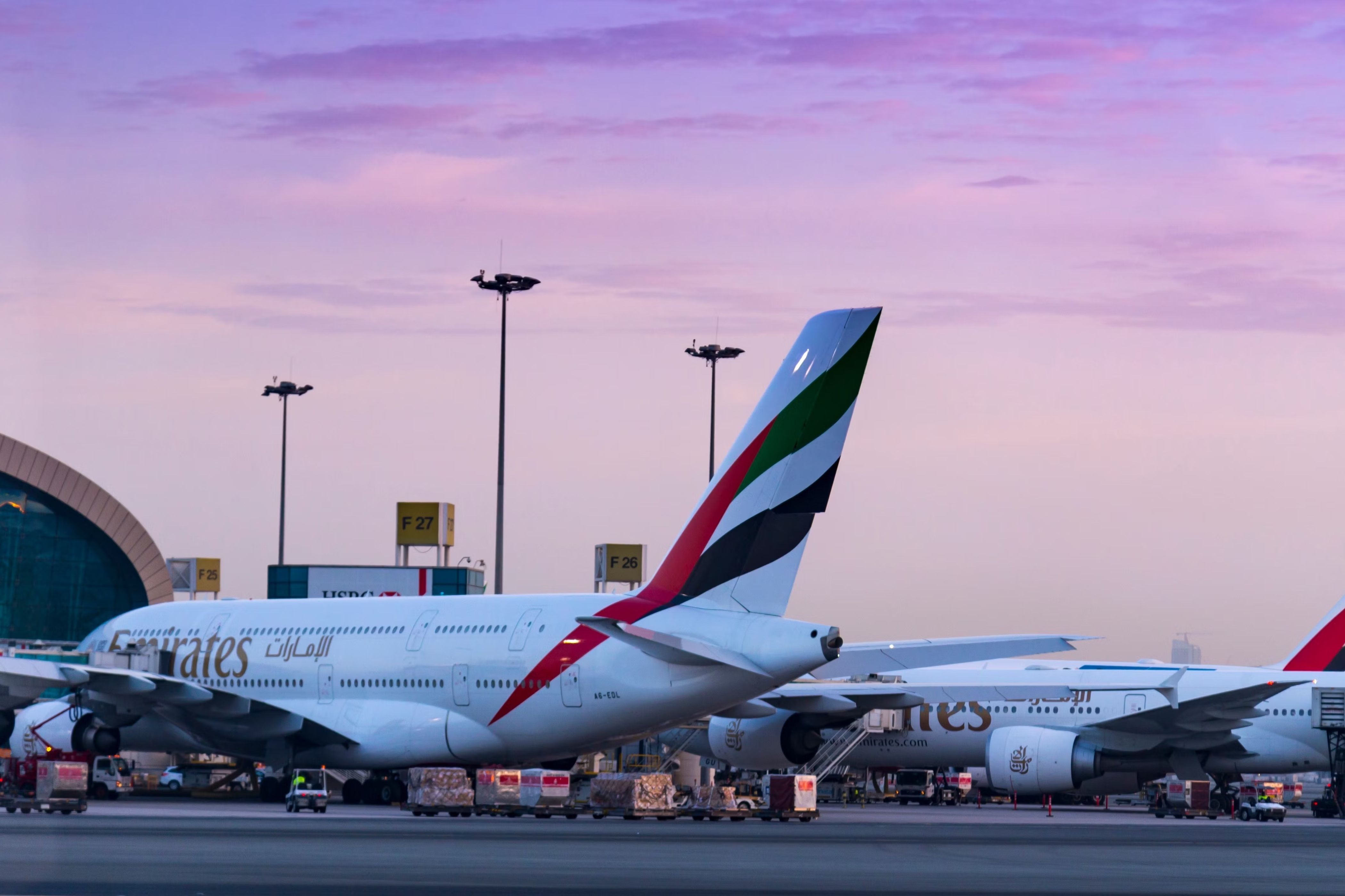 An Emirates A380 next to two Boeing 777s at Dubai International Airport.