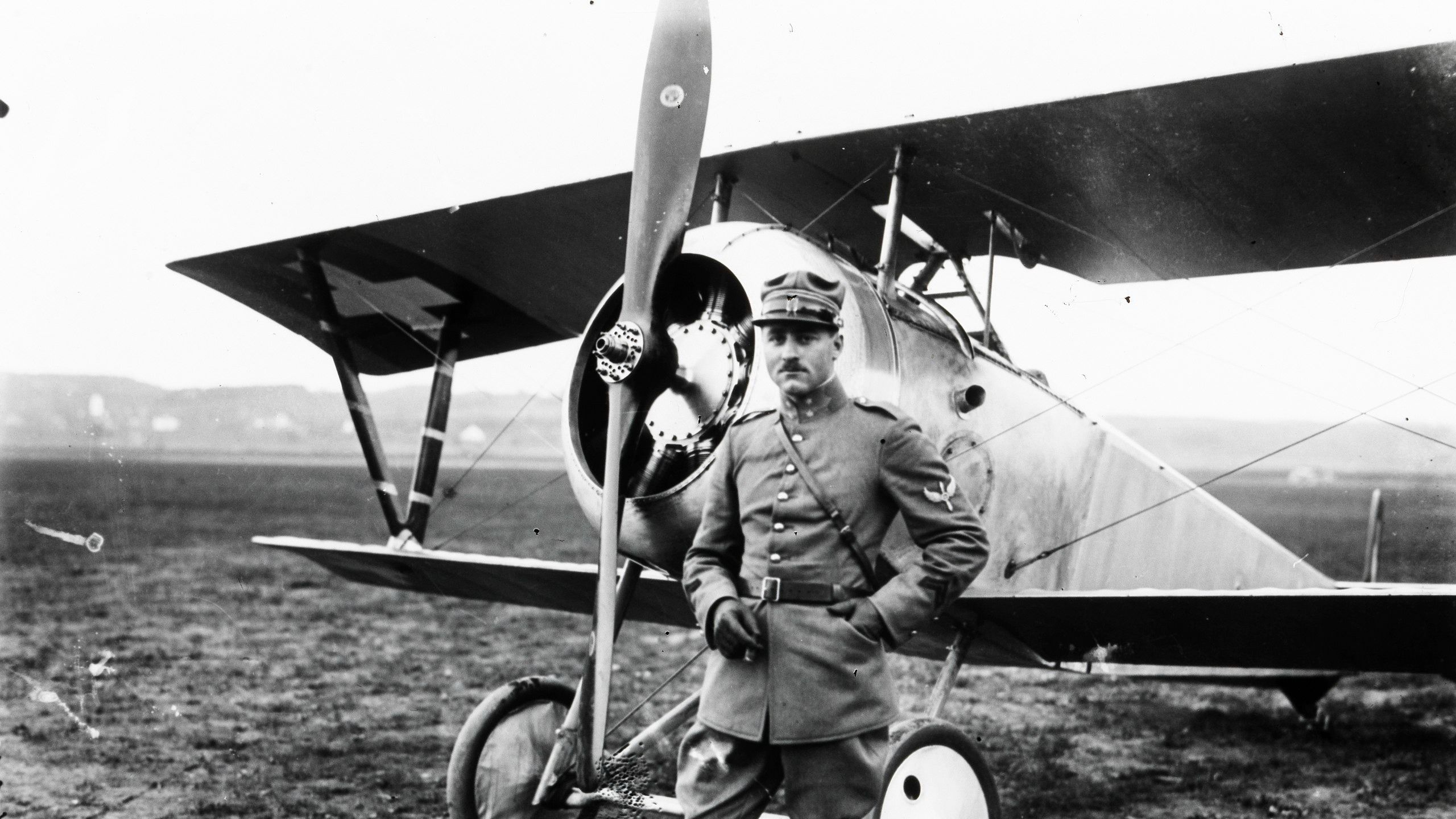 Oskar Bider standing next to a single engine light aircraft.