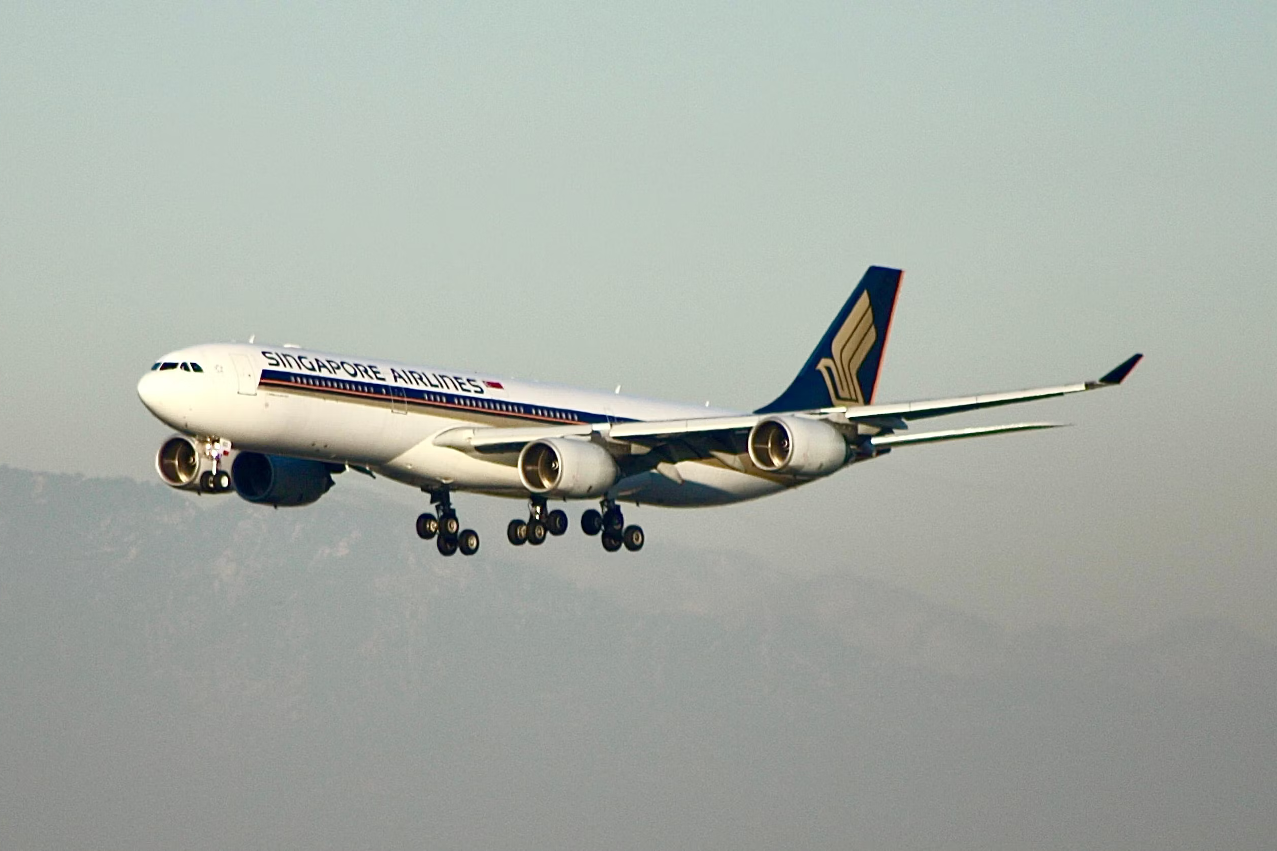 A Singapore Airlines A340-300 flying in the sky.