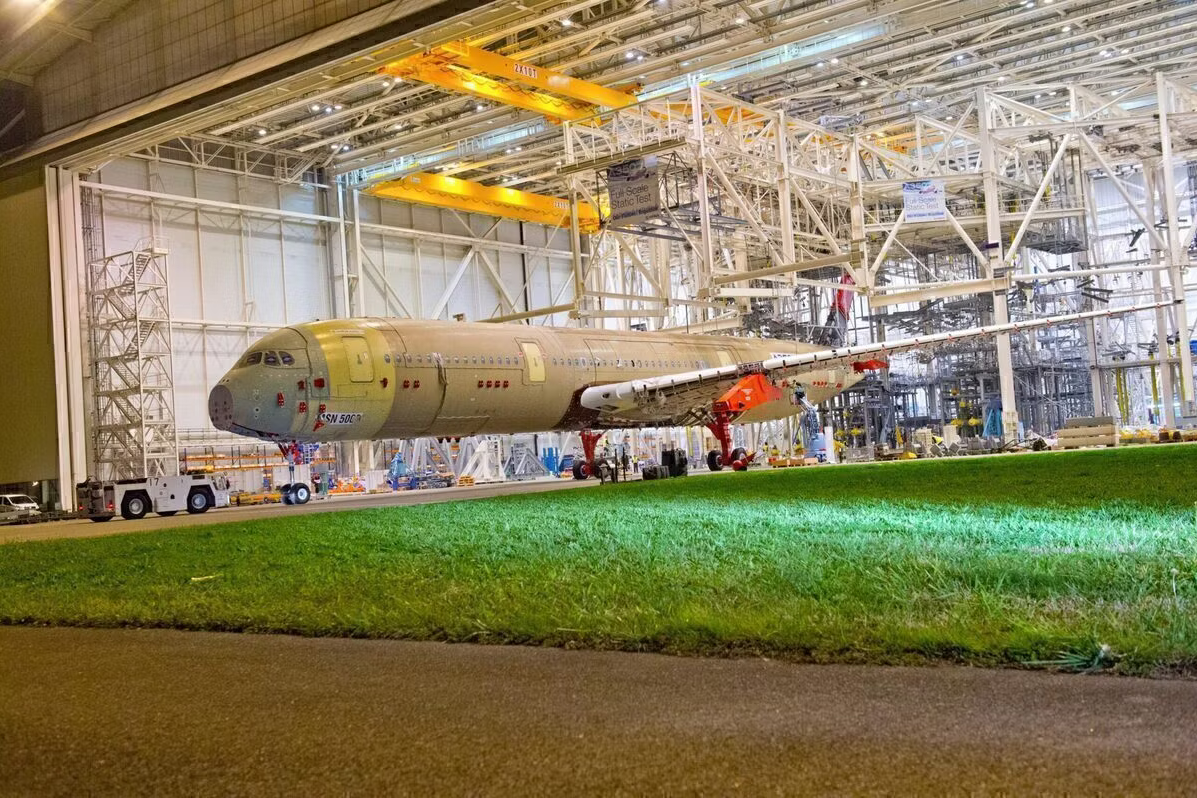 An Airbus A350 XWB being pushed into a hangar.