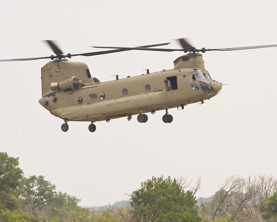 A US Army Boeing CH-47 Chinook hovering close to the ground.