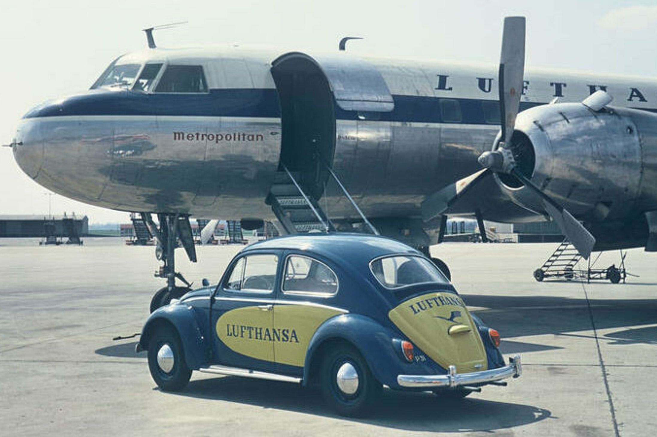 A Volkswagen with Lufthansa's logo and a Lufthansa plane in the back.