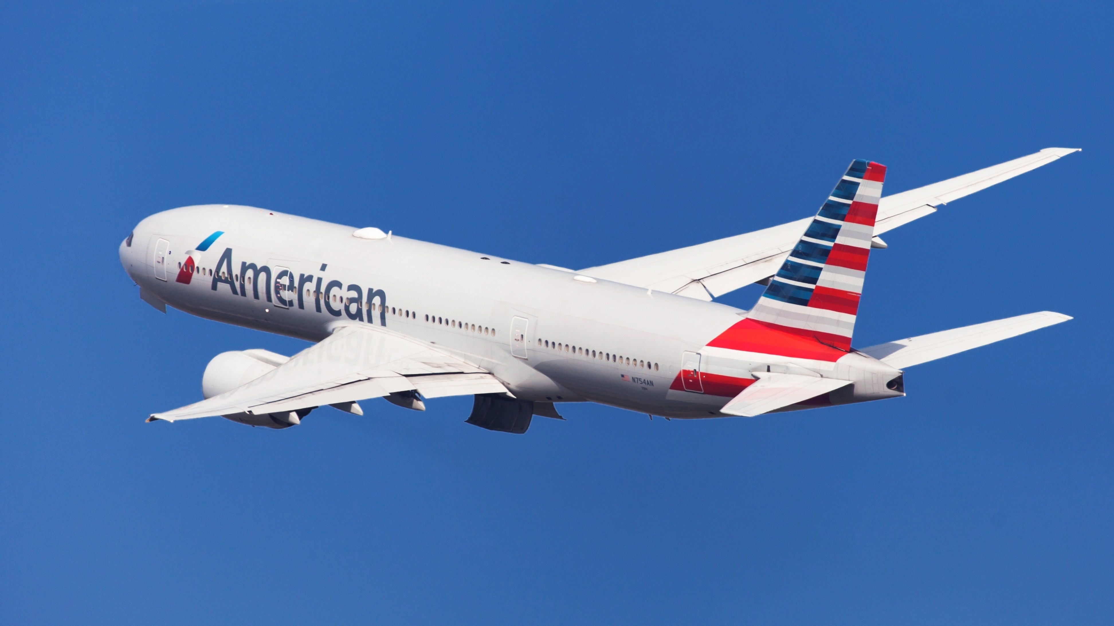 An American Airlines Boeing 777-200ER flying in the sky.