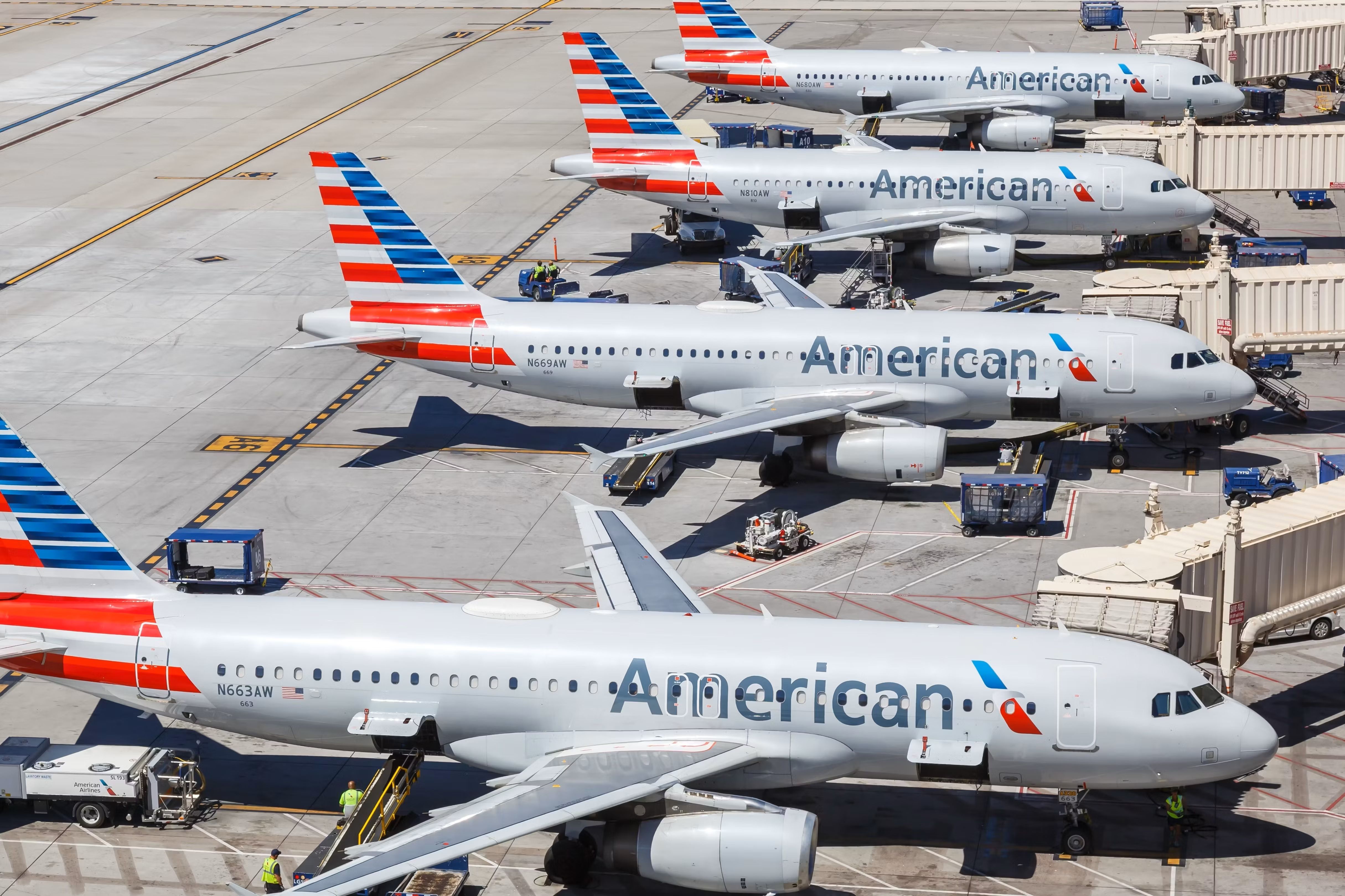 Four American Airlines aircraft parked at airport gates.