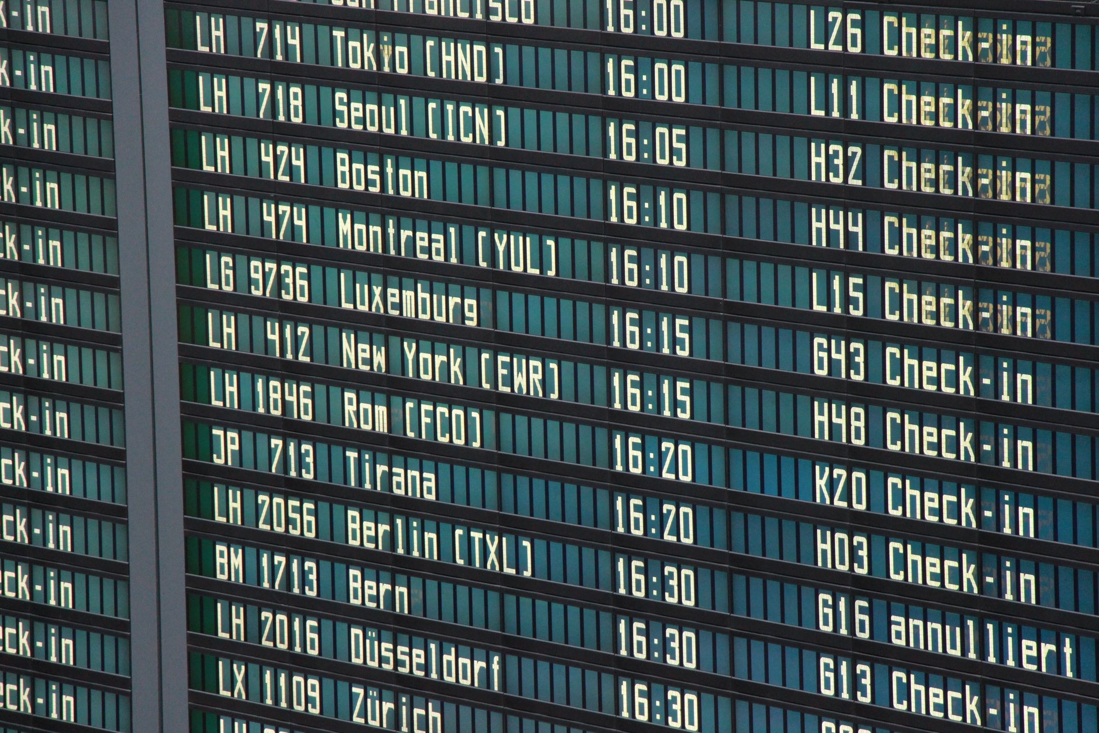 A departure board in Germany featuring flights to major cities all over the world..