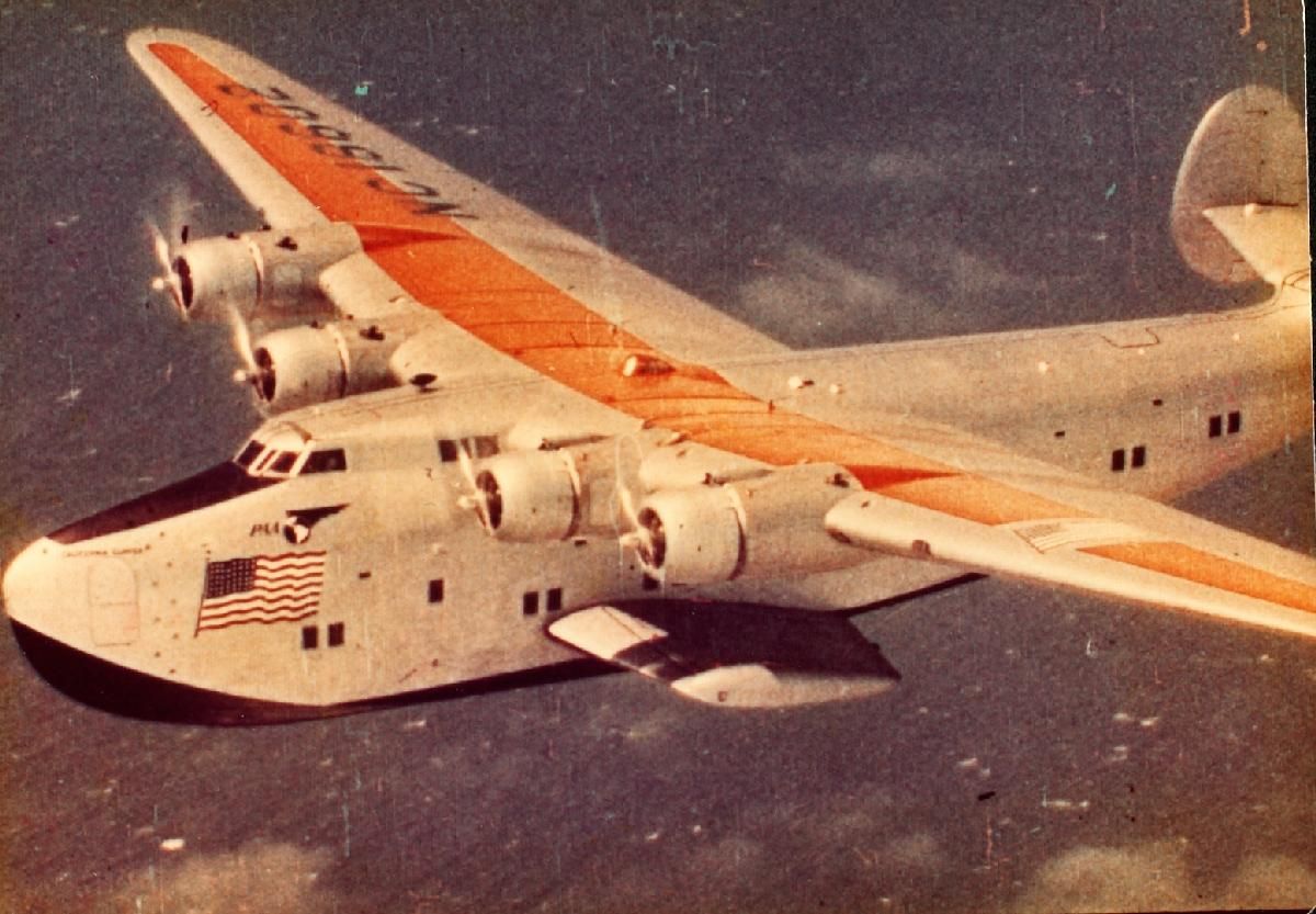 A Boeing 314 Clipper flying over water.