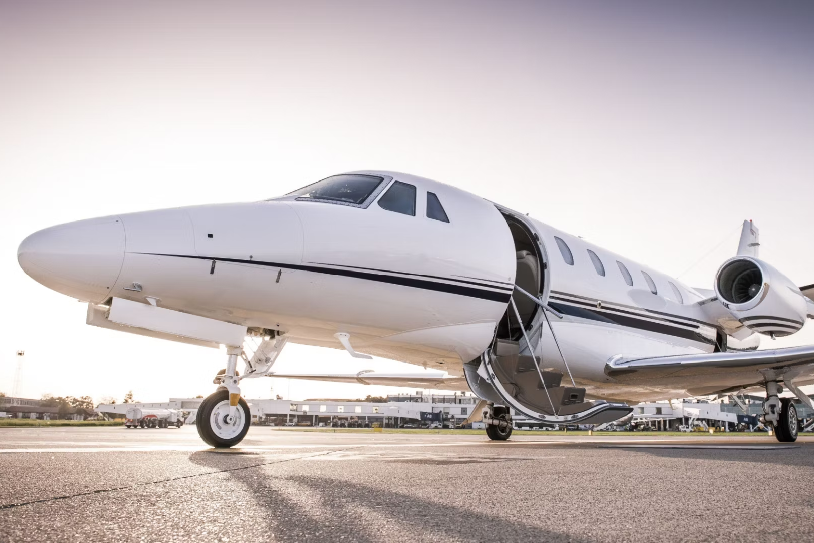 A Luxury business jet parked at an airfield with its stairs down.