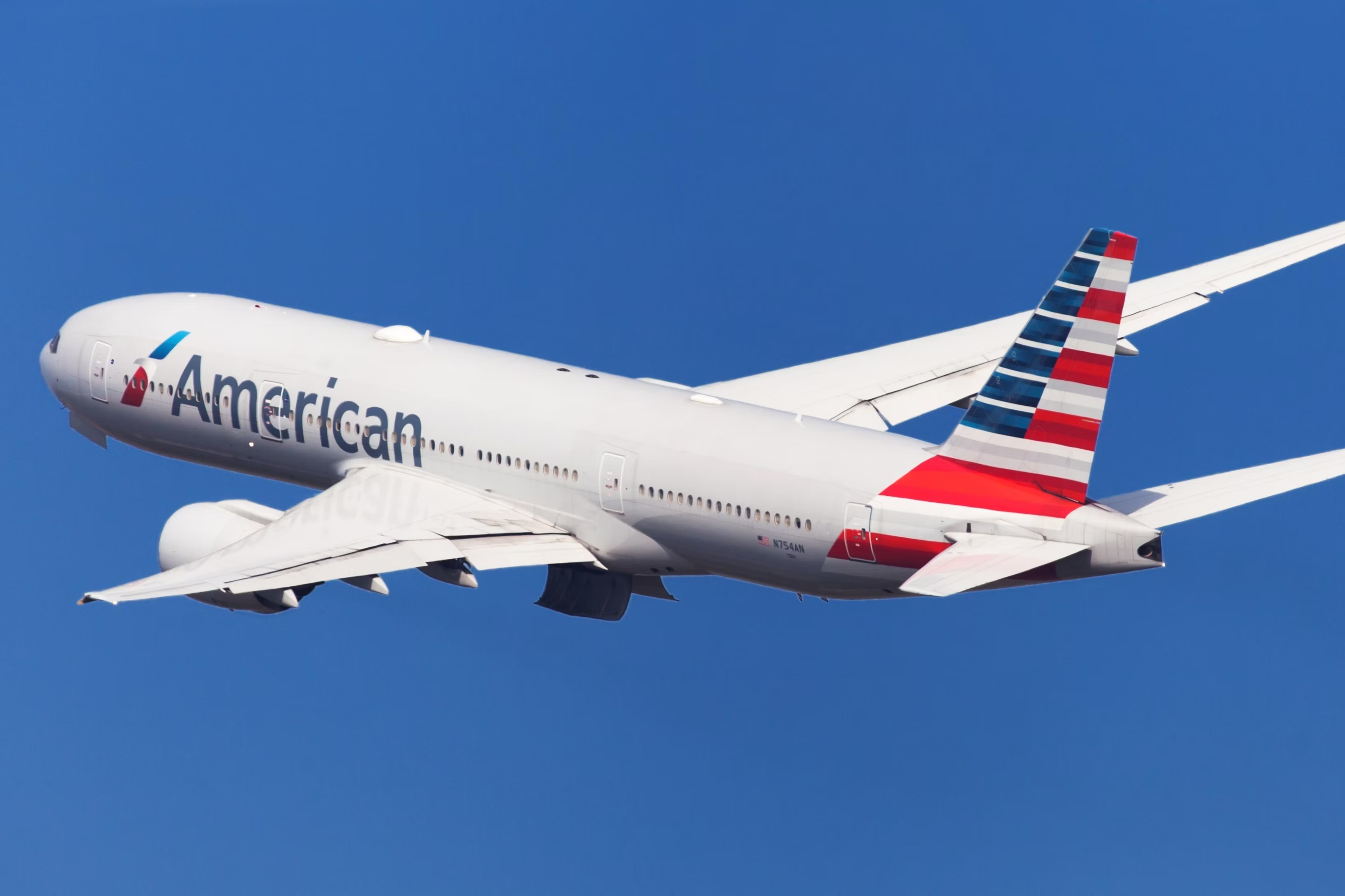 An American Airlines Boeing 777-200ER flying in the sky.