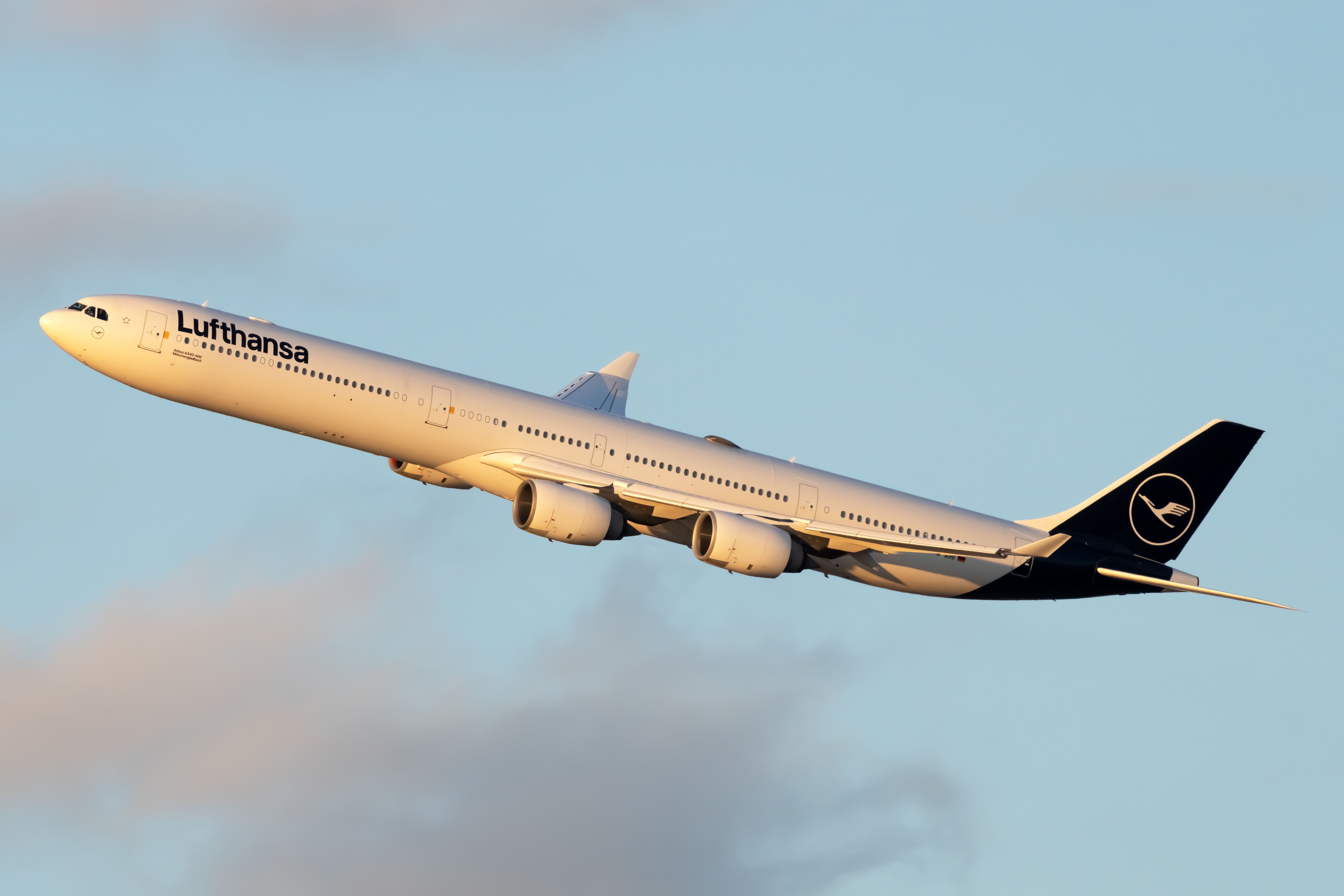 A Lufthansa Airbus A340 flying in the sky.