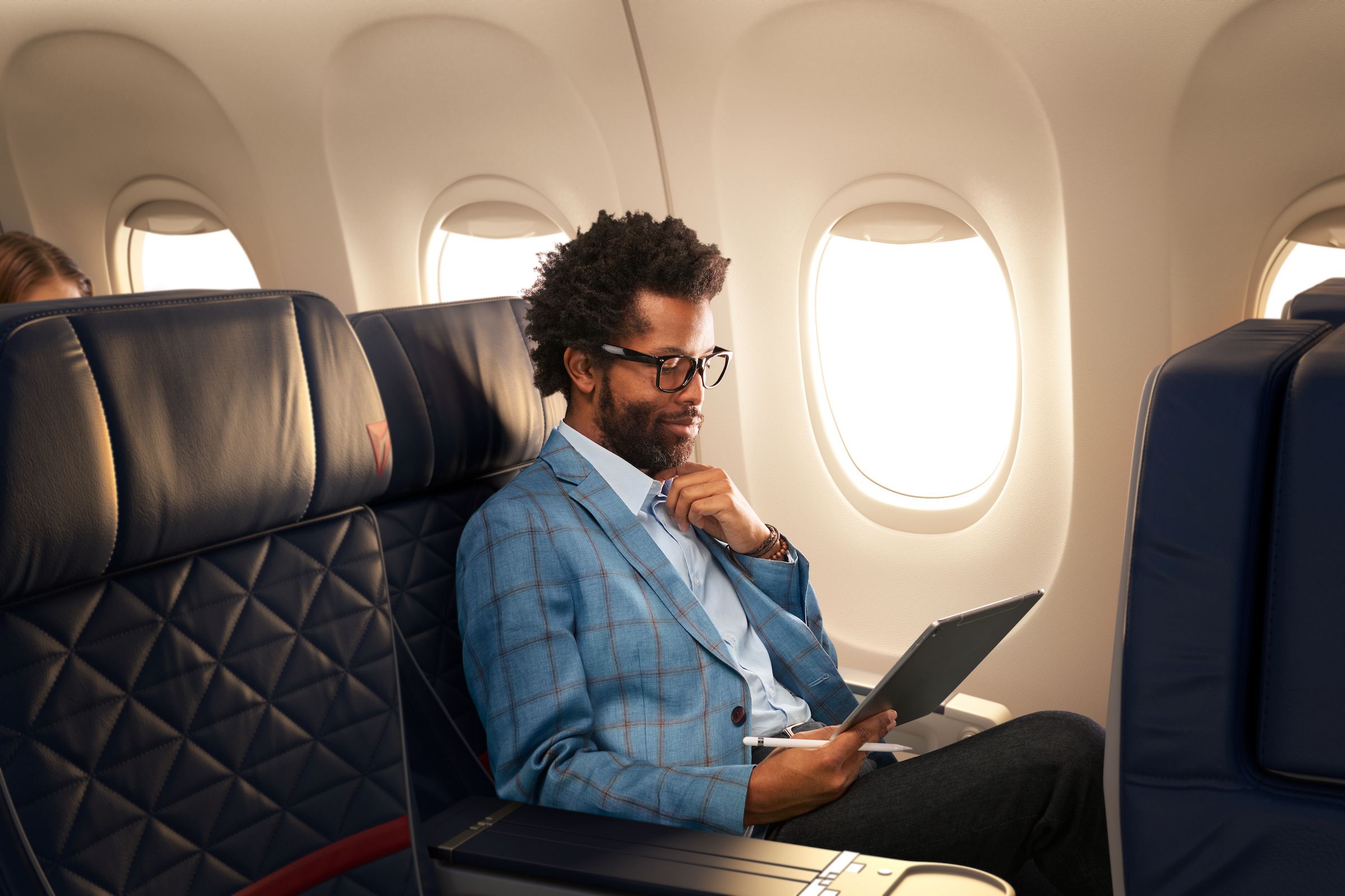 A Delta Air Lines passenger using a tablet during a flight.