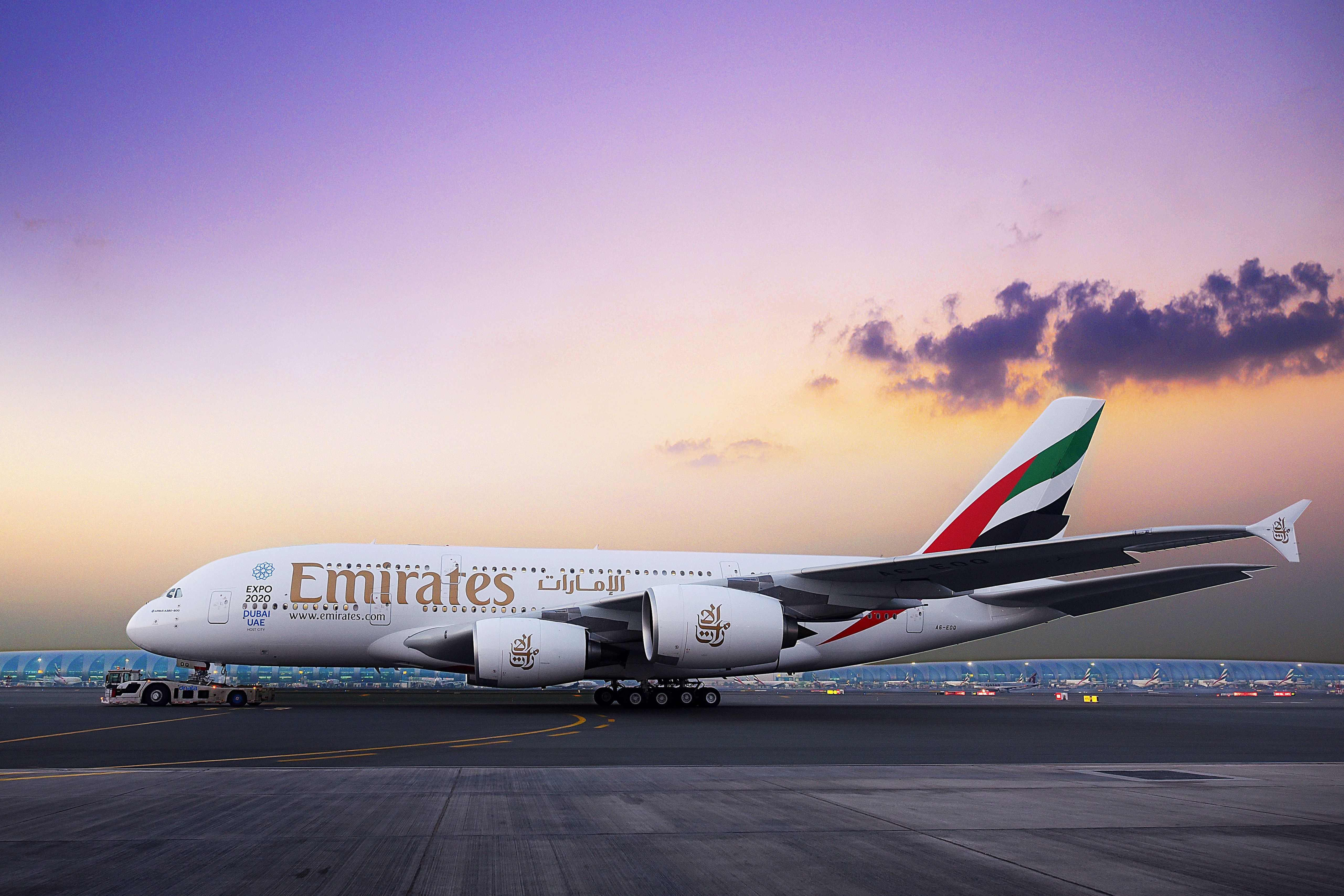 An Emirates Airbus A380 taxiing at sunset.