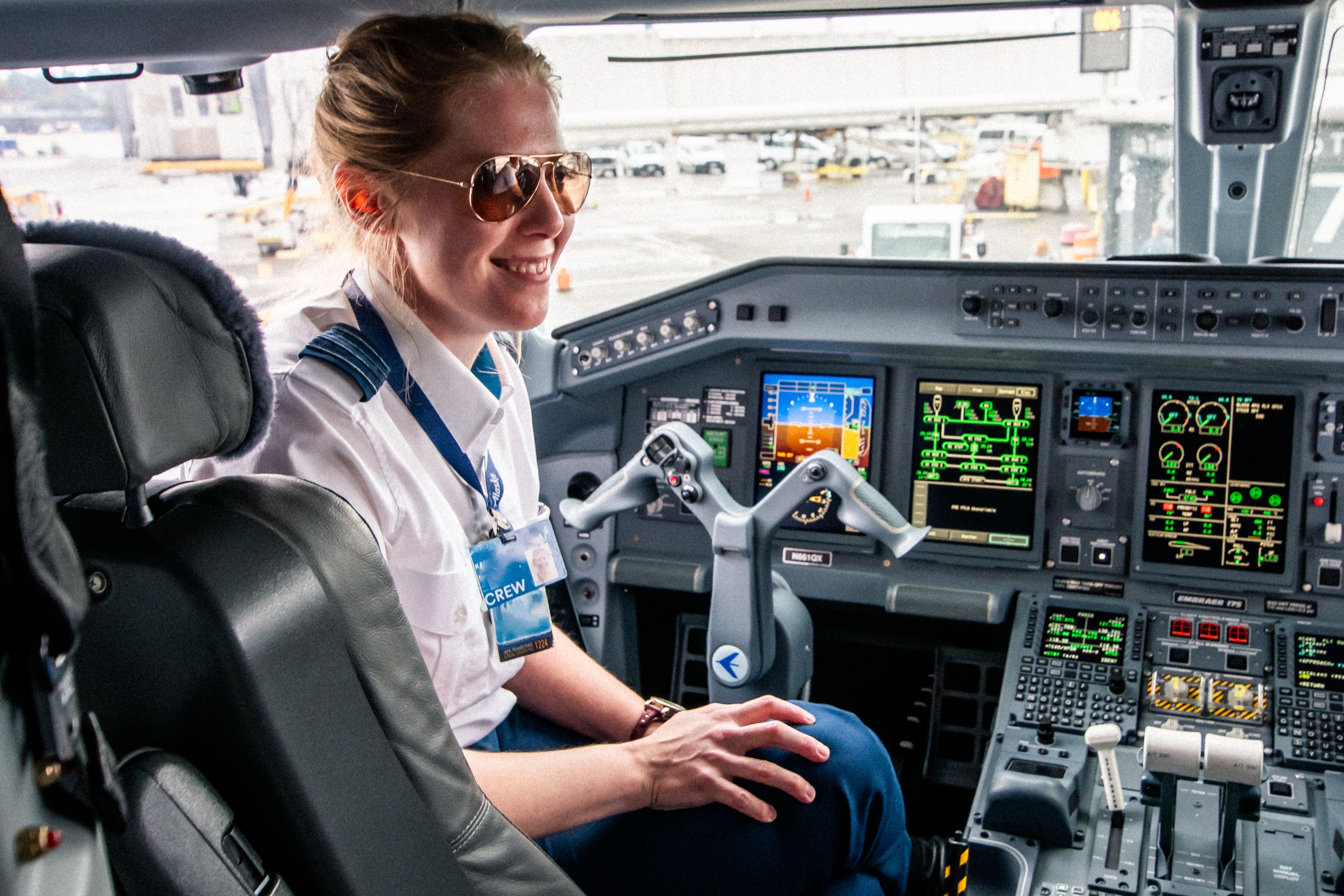 A pilot sitting in the captain's seat of an airliner.