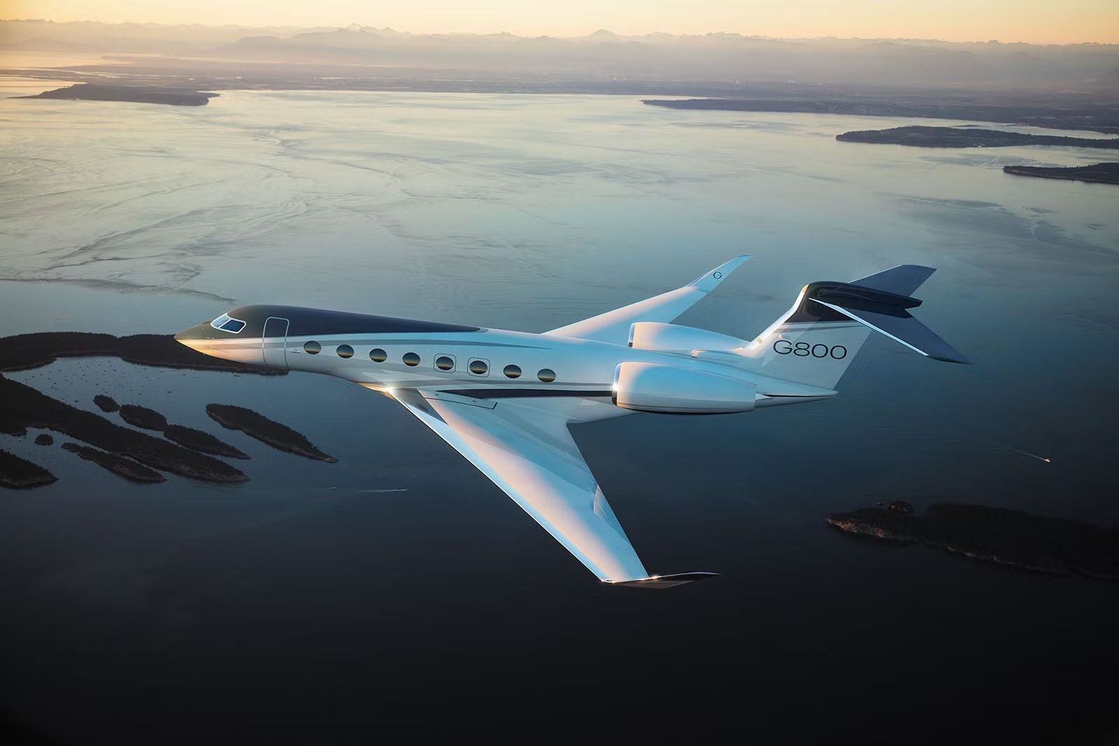 A Gulfstream G800 flying over water.