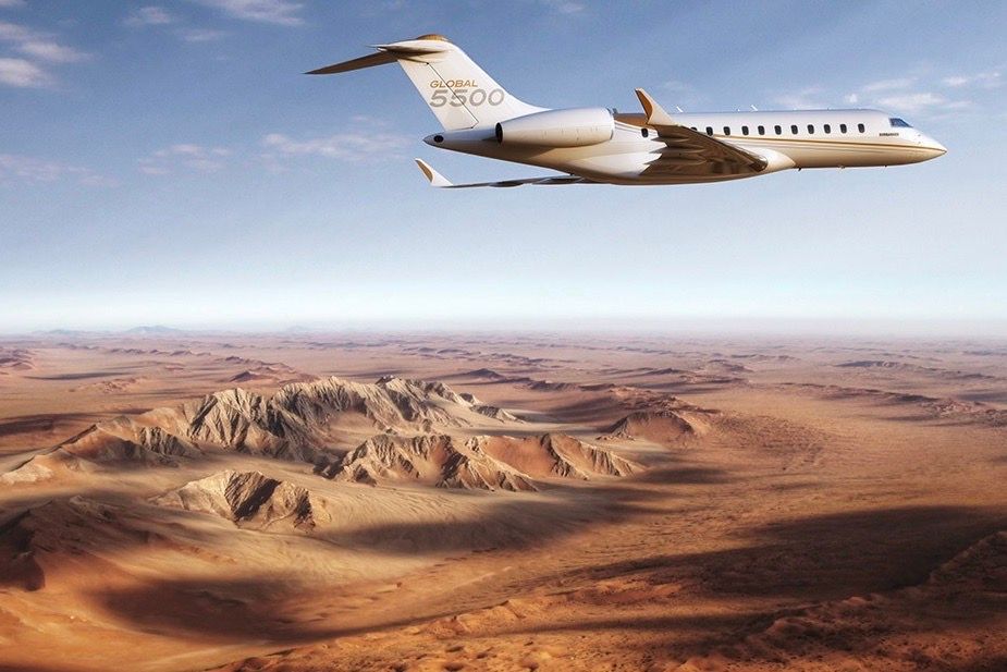 A Bombardier Global 5500 flying over a desert.