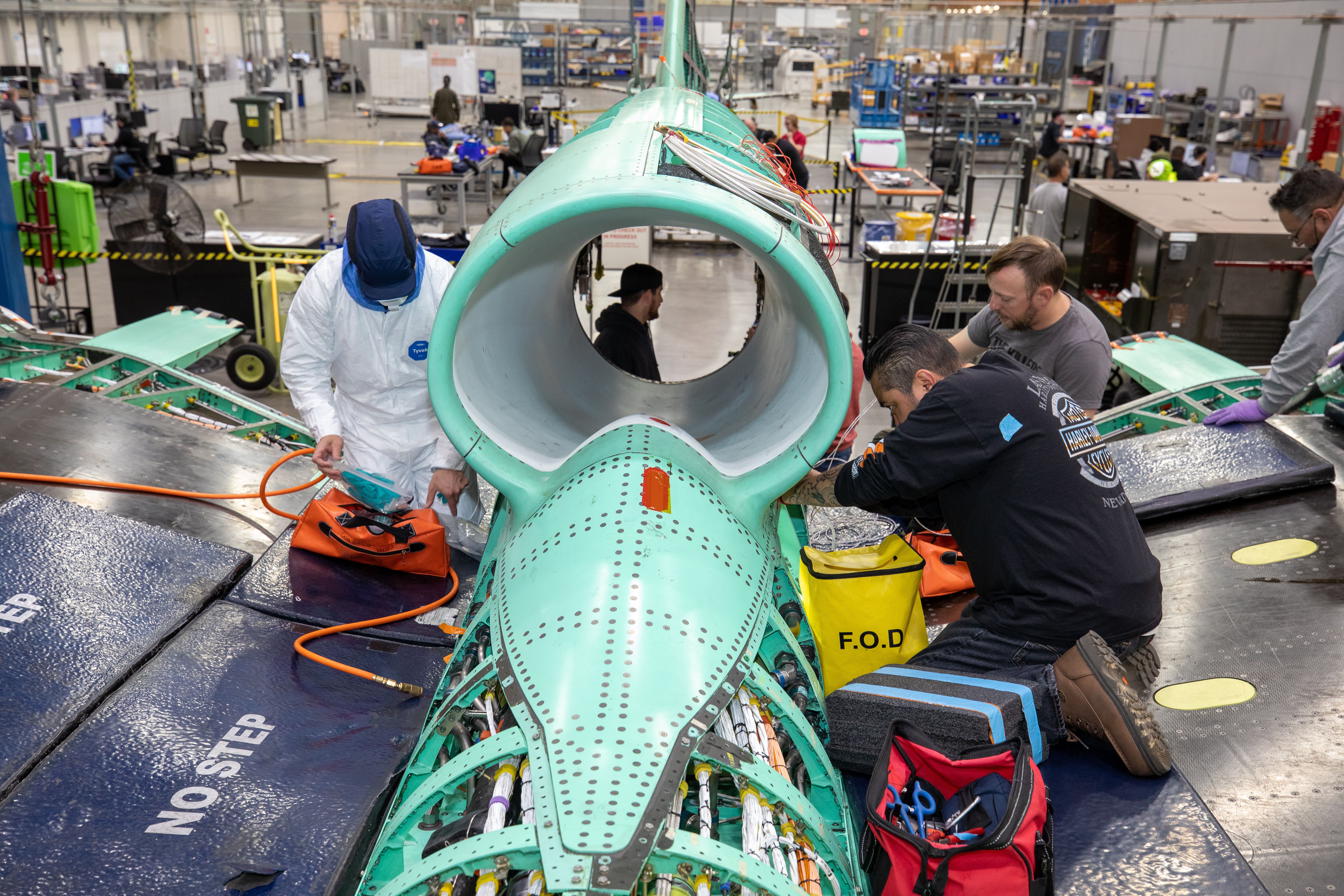 The X-59 team working on the aircraft’s wiring around the engine inlet prior to the engine being installed.