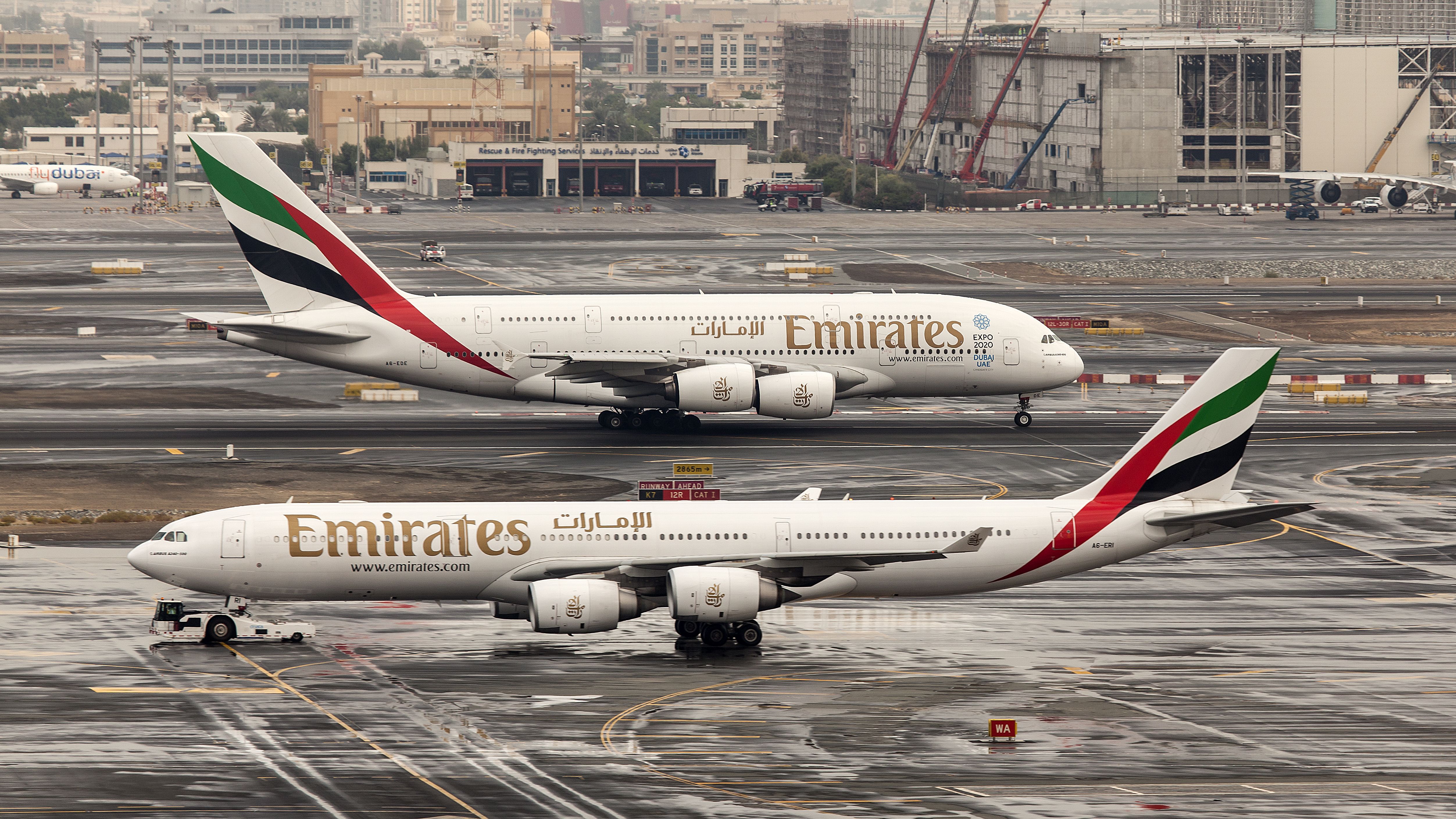 An Emirates A340 and A380 on the airport apron.