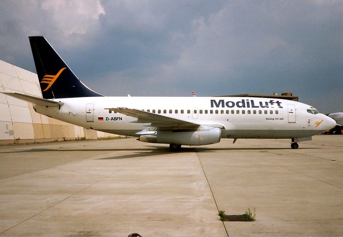 A ModiLuft Boeing 737-200 parked at an airport.