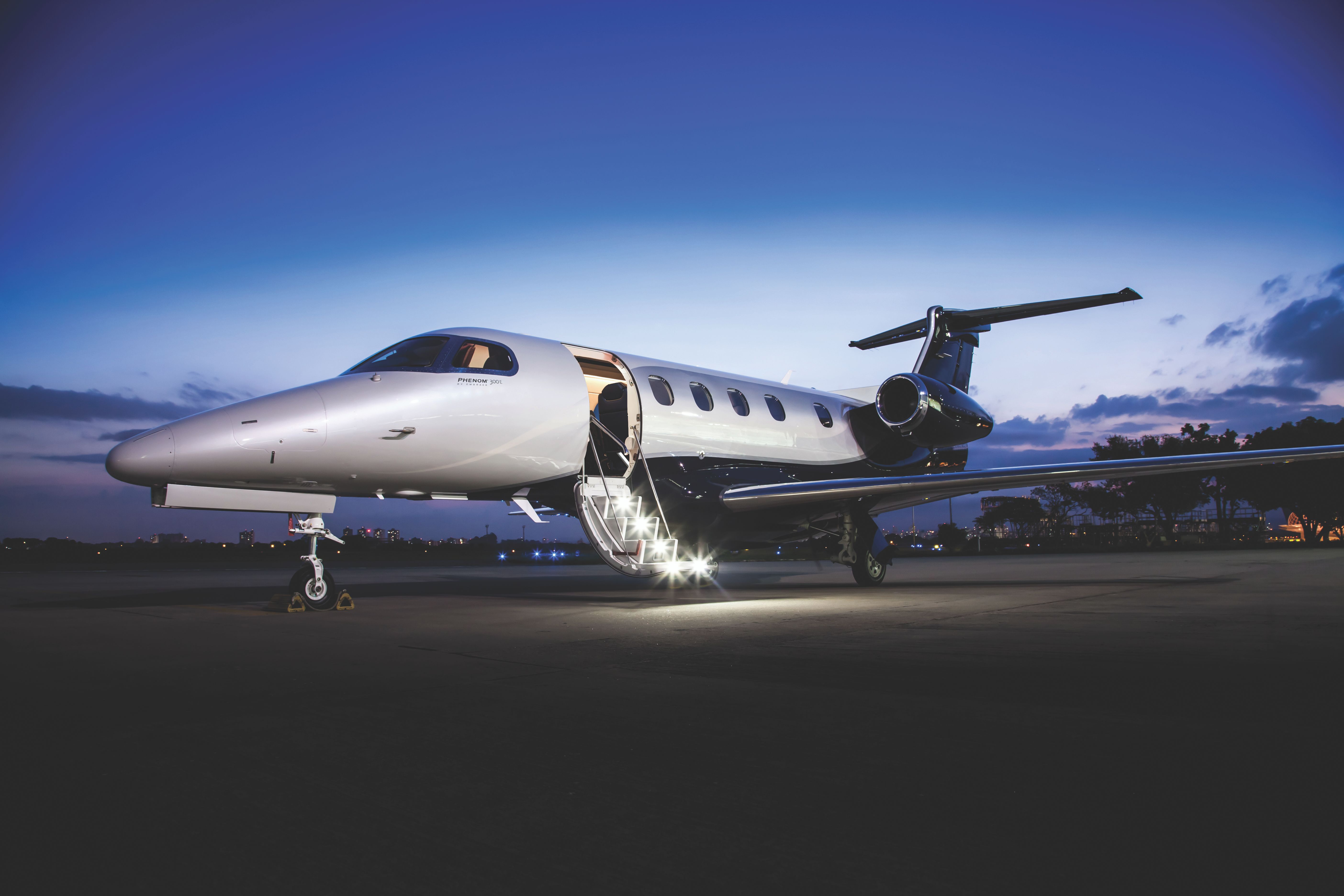 An Embraer Phenom 300E parked at an airport.