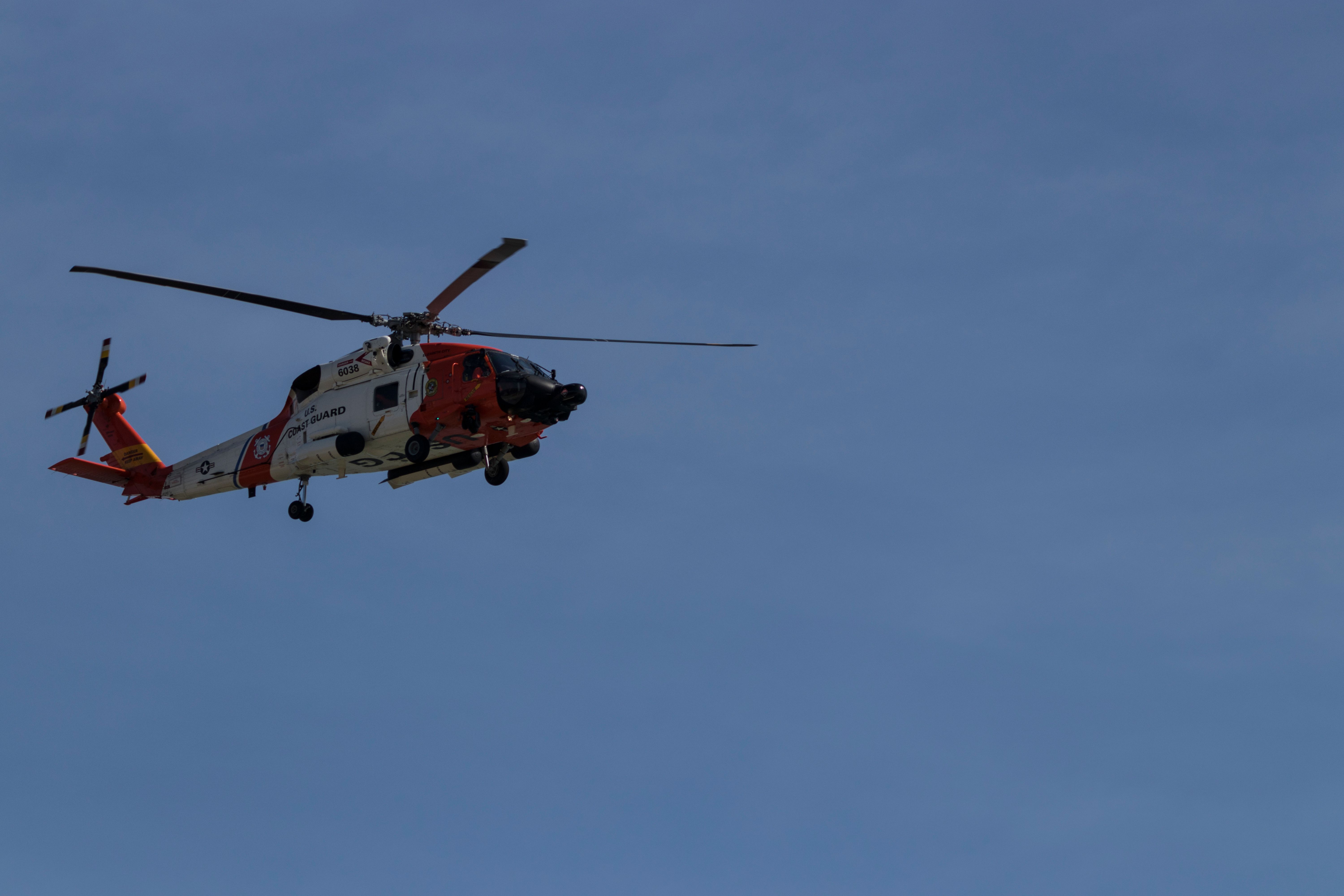 U.S. Coast Guard Sikorksy MH-60 Jayhawk rescue helicopter flies over the Atlantic Coast in Virginia Beach on routine patrol.
